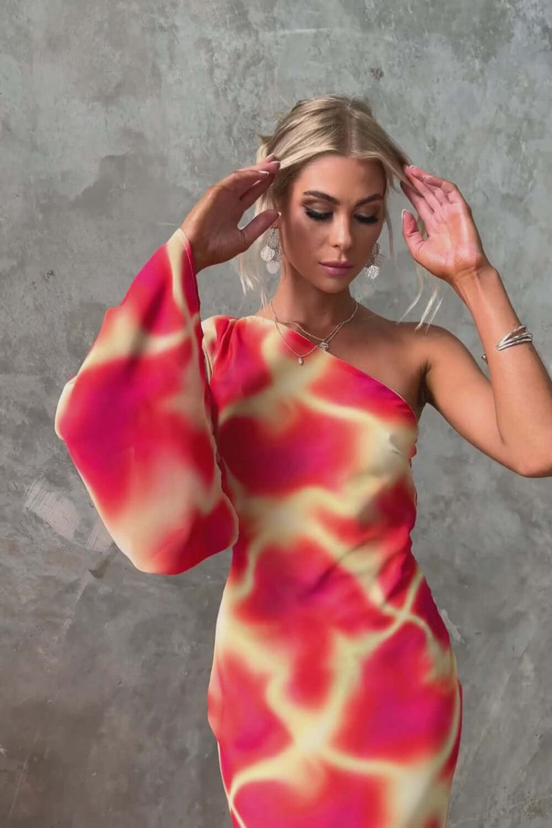 Model showcasing the Kansai Maxi Dress with one-shoulder neckline, vibrant colors, and flowing sleeve design.