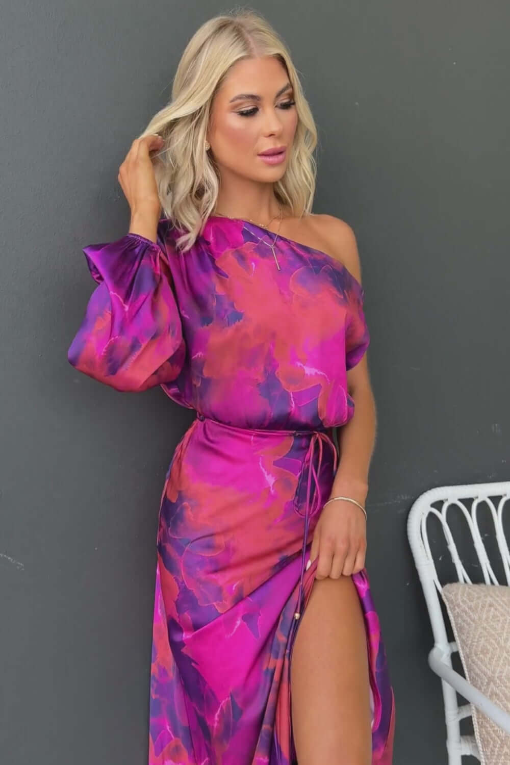 Woman in Winona Maxi Dress featuring asymmetric neckline, satin material, and a stylish front split.