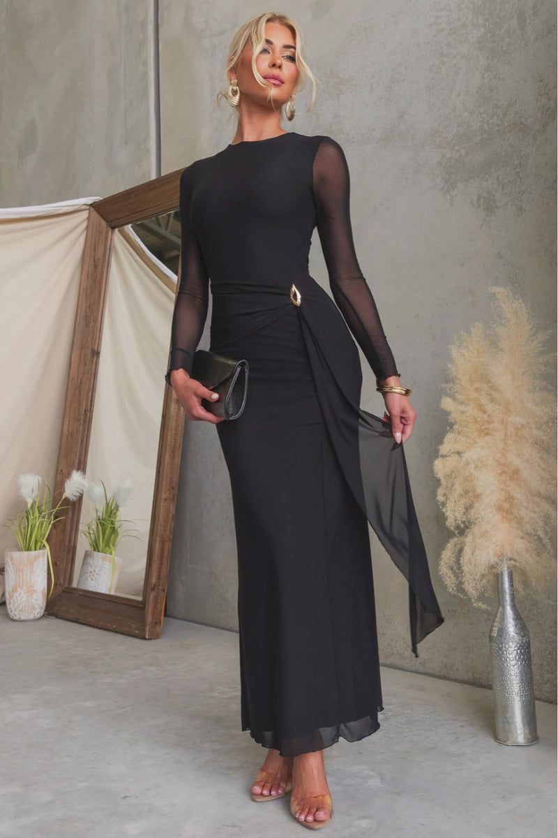 Stunning woman wearing the La Rose Maxi Dress with round neckline and gold hardware, styled with a black clutch.