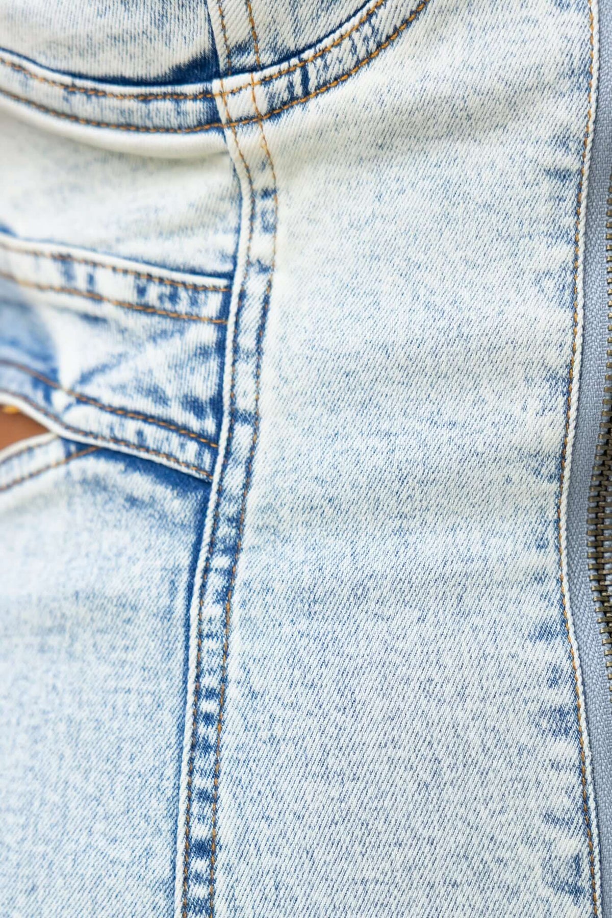 Close-up of Prim Denim Dress showing denim texture, adjustable straps, and zip-up detail for women’s fashion.