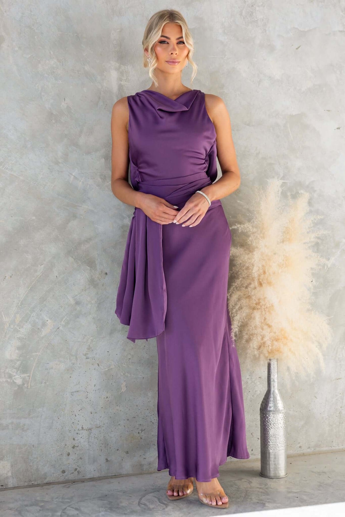 Qalenna Maxi Dress in purple satin, featuring high neckline, open back, and removable brooch for versatile styling.