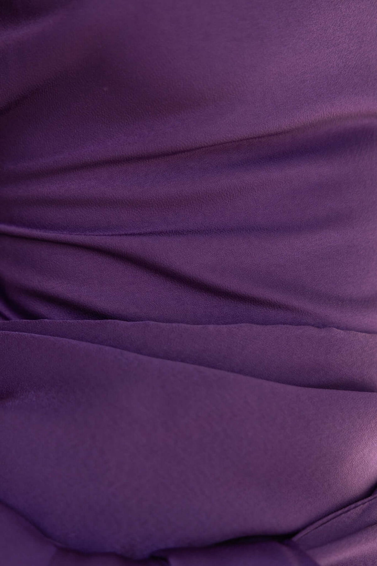 Close-up of luxurious purple satin fabric showcasing the soft drape and smooth texture of the Qalenna Maxi Dress.