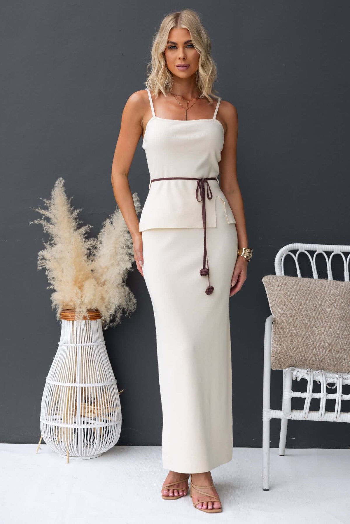 Elegant Qarmy top with adjustable straps and removable tie, styled with a long beige skirt, showcasing knit material.