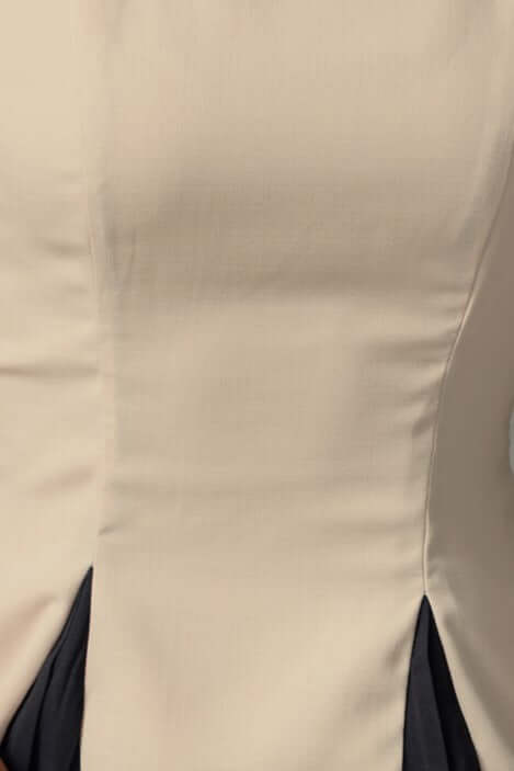 Close-up of Qelso Dress showing high neckline and elegant fabric detailing in beige and black.