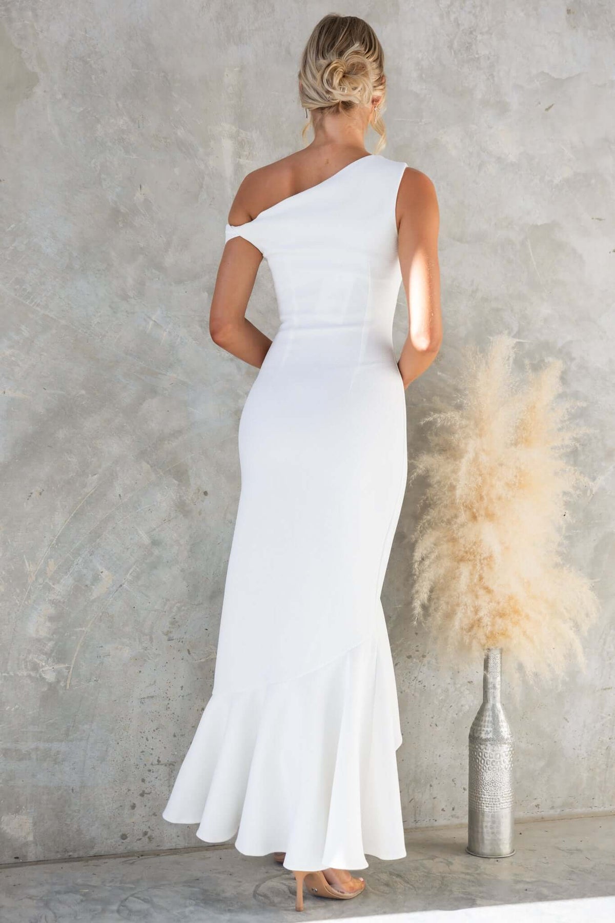 Back view of Raleigh Maxi Dress with asymmetric neckline and flared hem, perfect for bridal occasions.