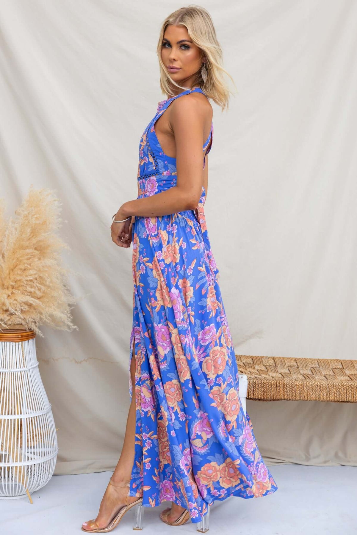 Model wearing Relly Maxi Dress with abstract floral print and high halter neckline, showcasing front split detail.