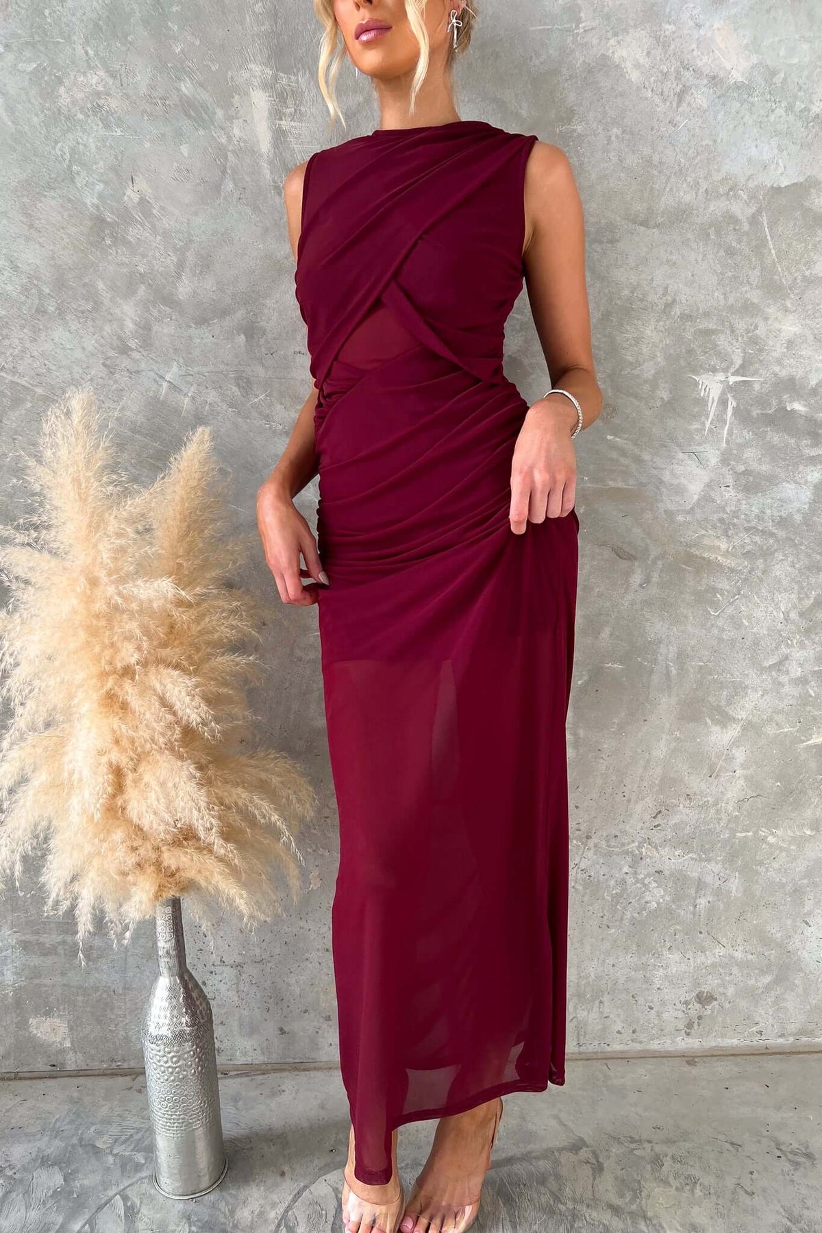 Woman in burgundy Rogers Maxi Dress with high neckline and mesh material, showcasing an elegant silhouette.