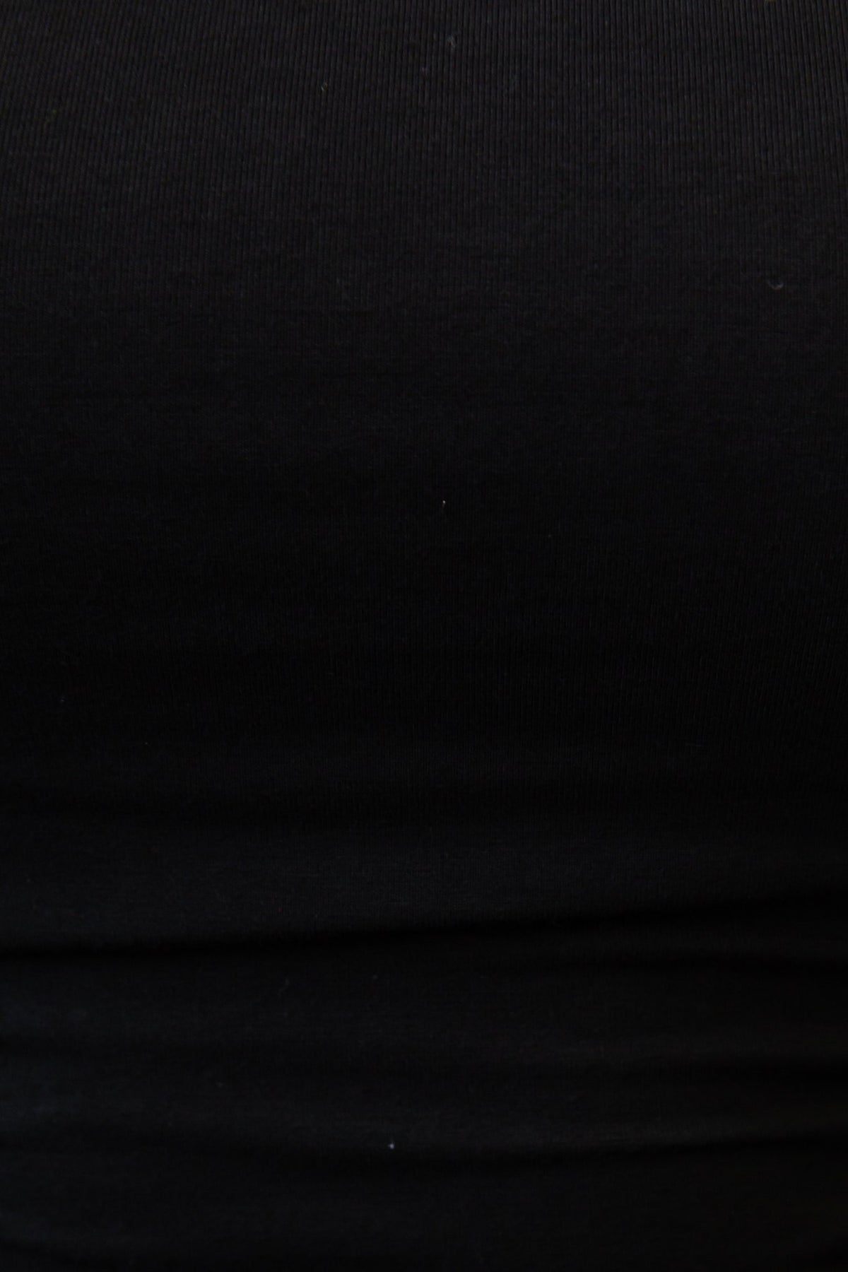 Close-up of a black stretchy top with a smooth texture, showcasing high neckline and lined material.