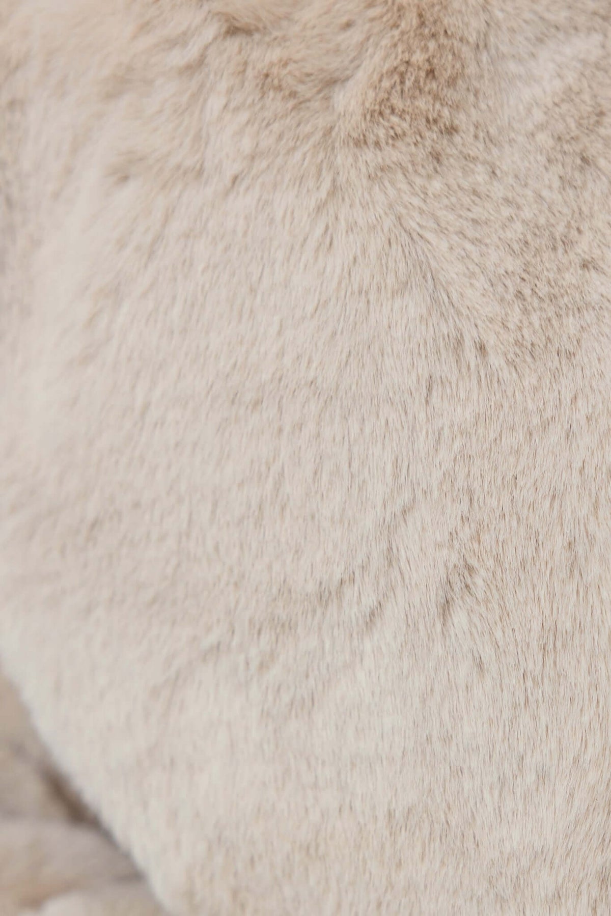 Close-up of soft, fluffy beige fabric ideal for coats, highlighting the luxurious texture and quality.
