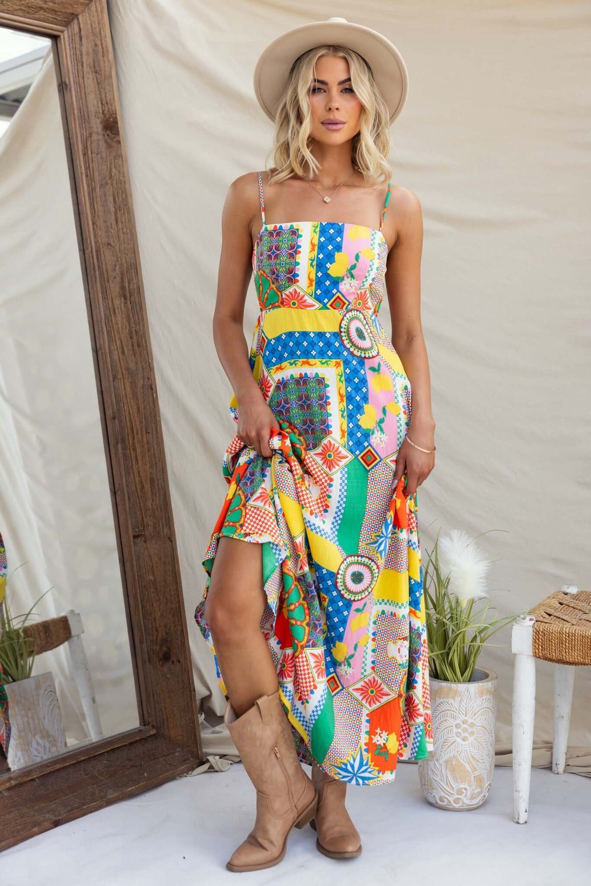 Colorful Salilah Maxi Dress with thin straps and pockets, styled with a hat and boots, perfect for summer outings.