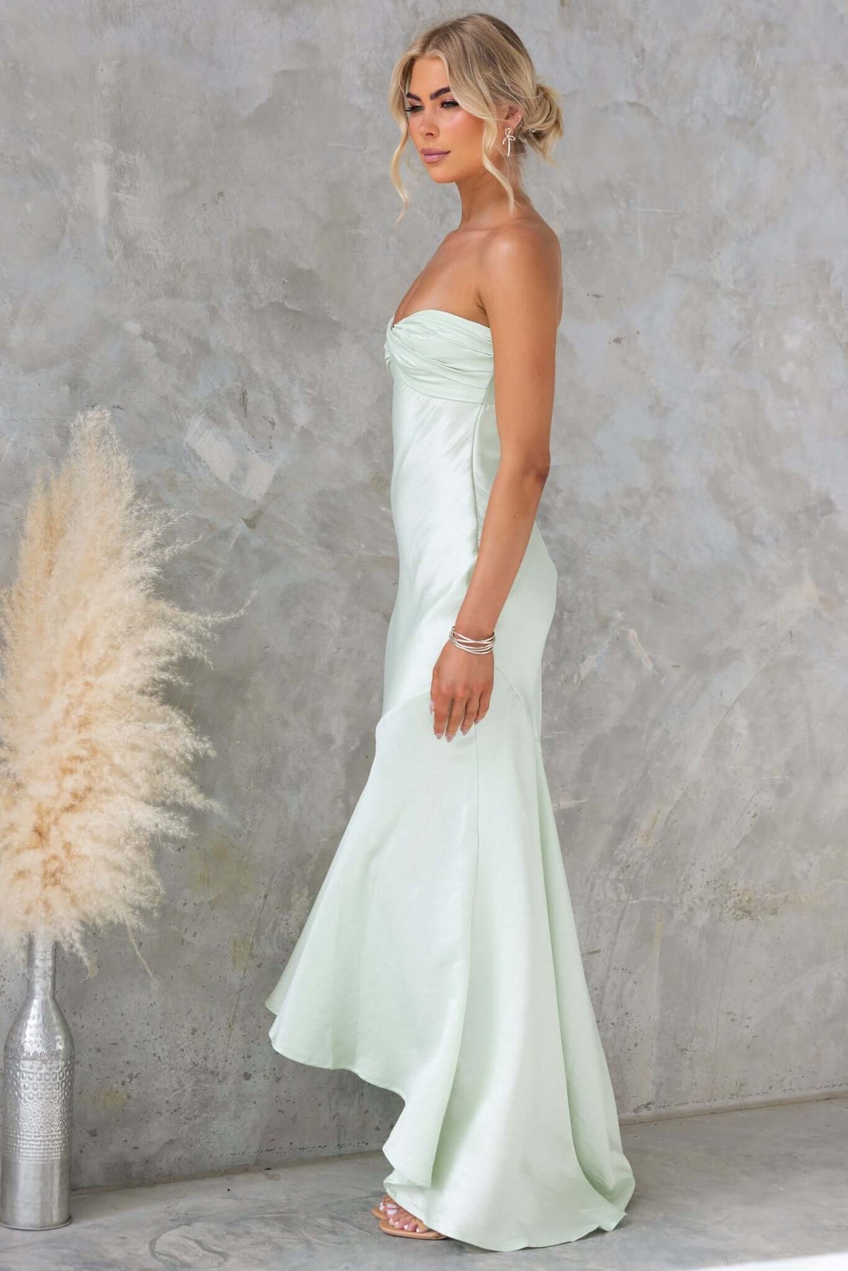 Strapless Sancia Maxi Dress in mint green, showcasing a slight sheen and elegant fit against a textured background.