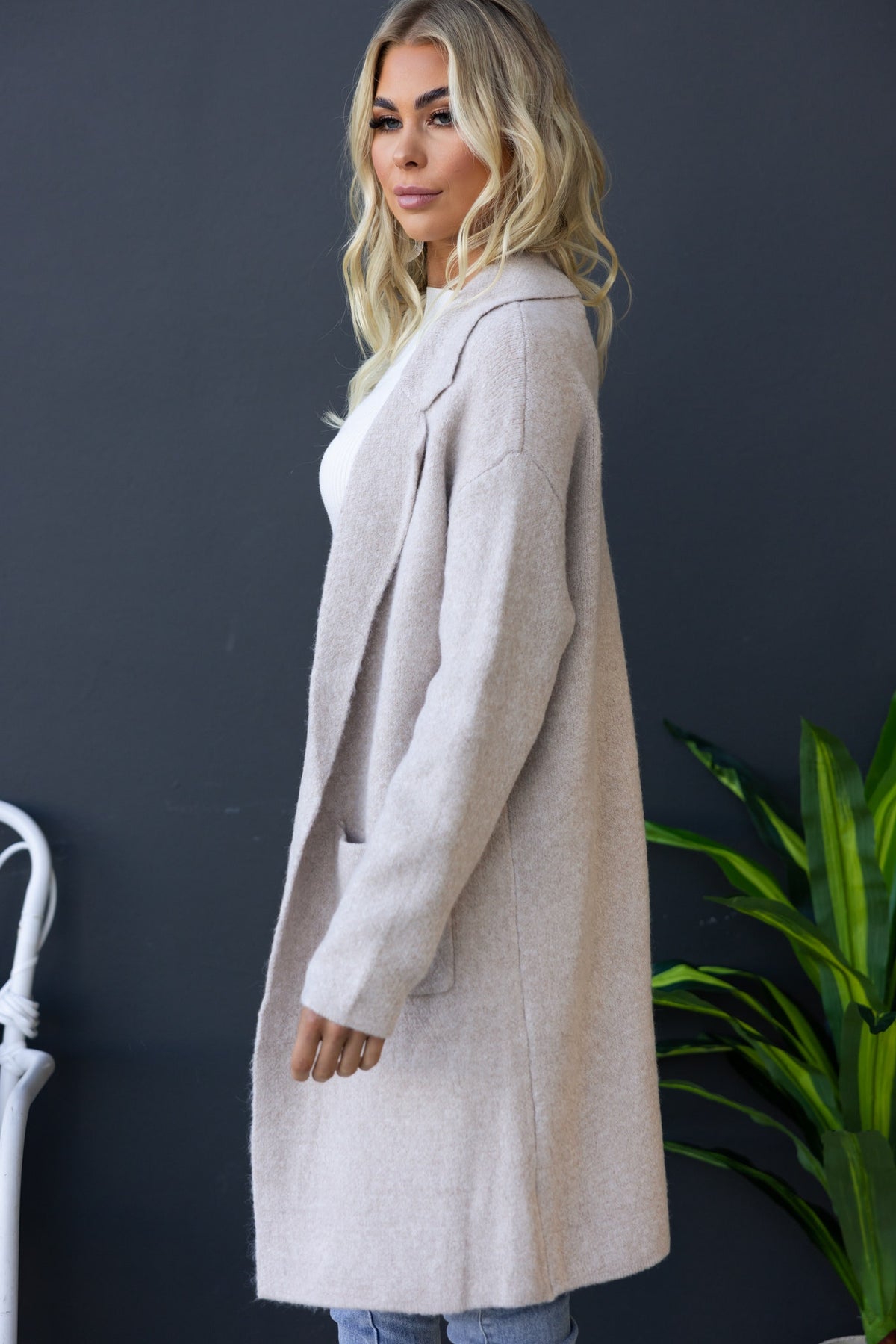 Side view of Sarlia Cardigan in light beige, featuring a collar, pockets, and a relaxed fit.