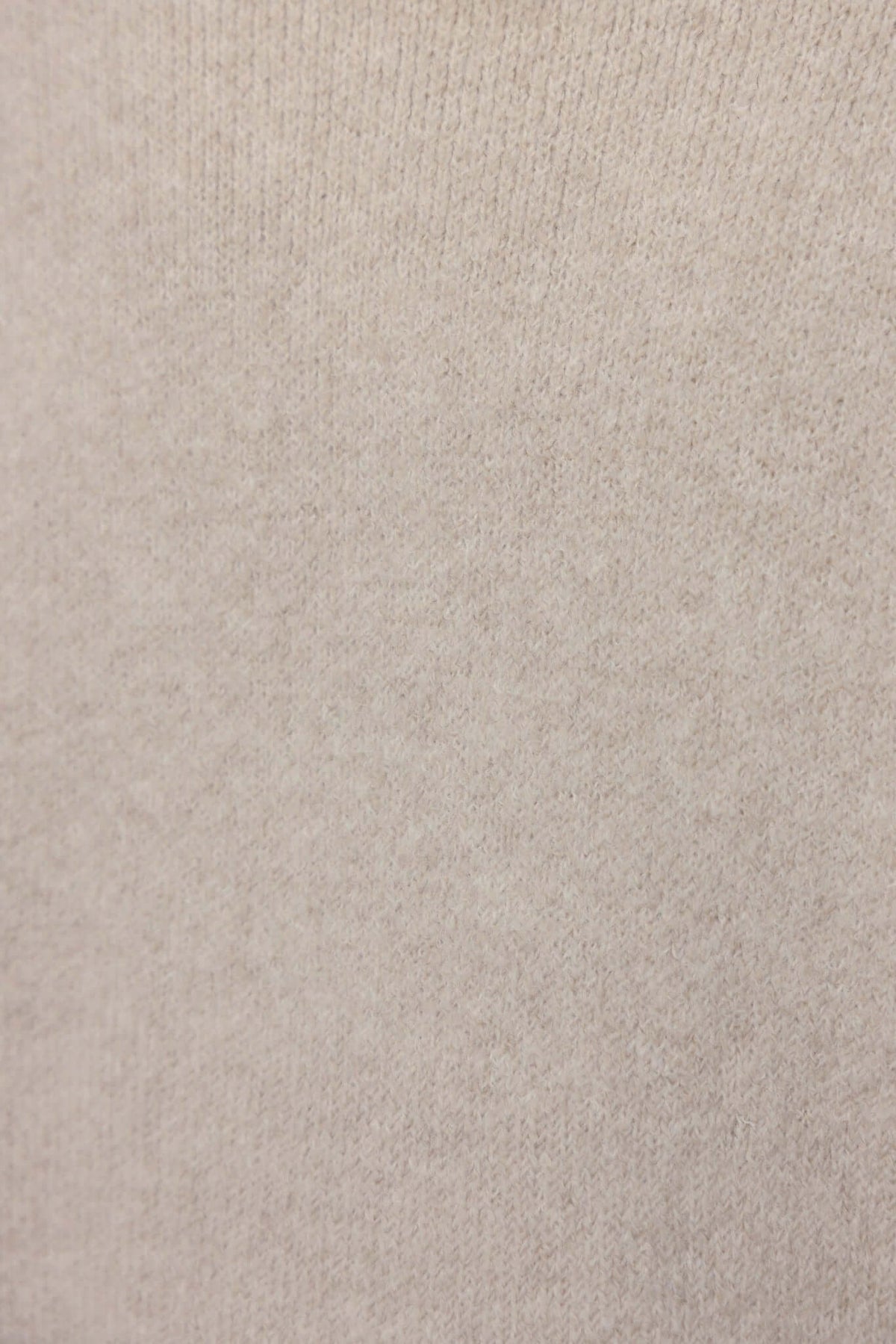 Close-up of Sarlia Cardigan knit fabric in soft beige, showcasing its texture and stretch material.