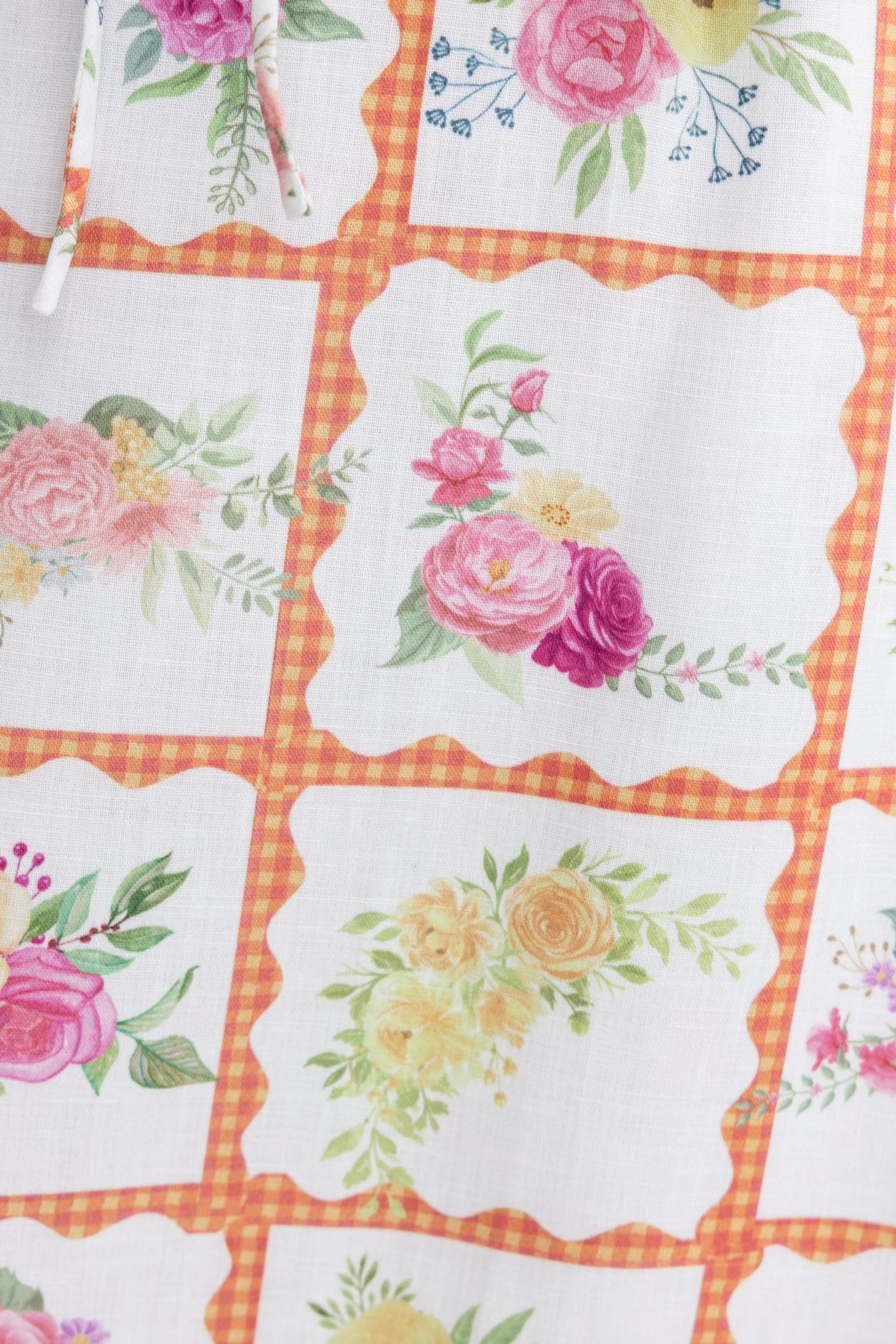 Floral patchwork design featuring roses and greenery on a lightweight fabric background.