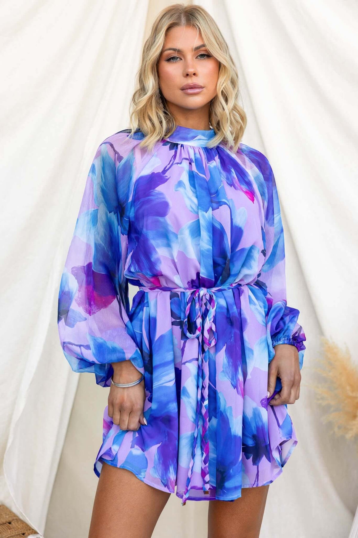 Model wearing a vibrant floral Siletto Dress with high neckline and elastic cuffs.