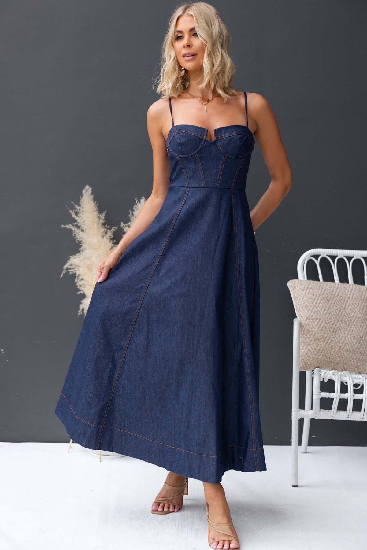 Model wearing Sylvi Denim Midi Dress with adjustable straps and boning, showcasing a classic denim style.