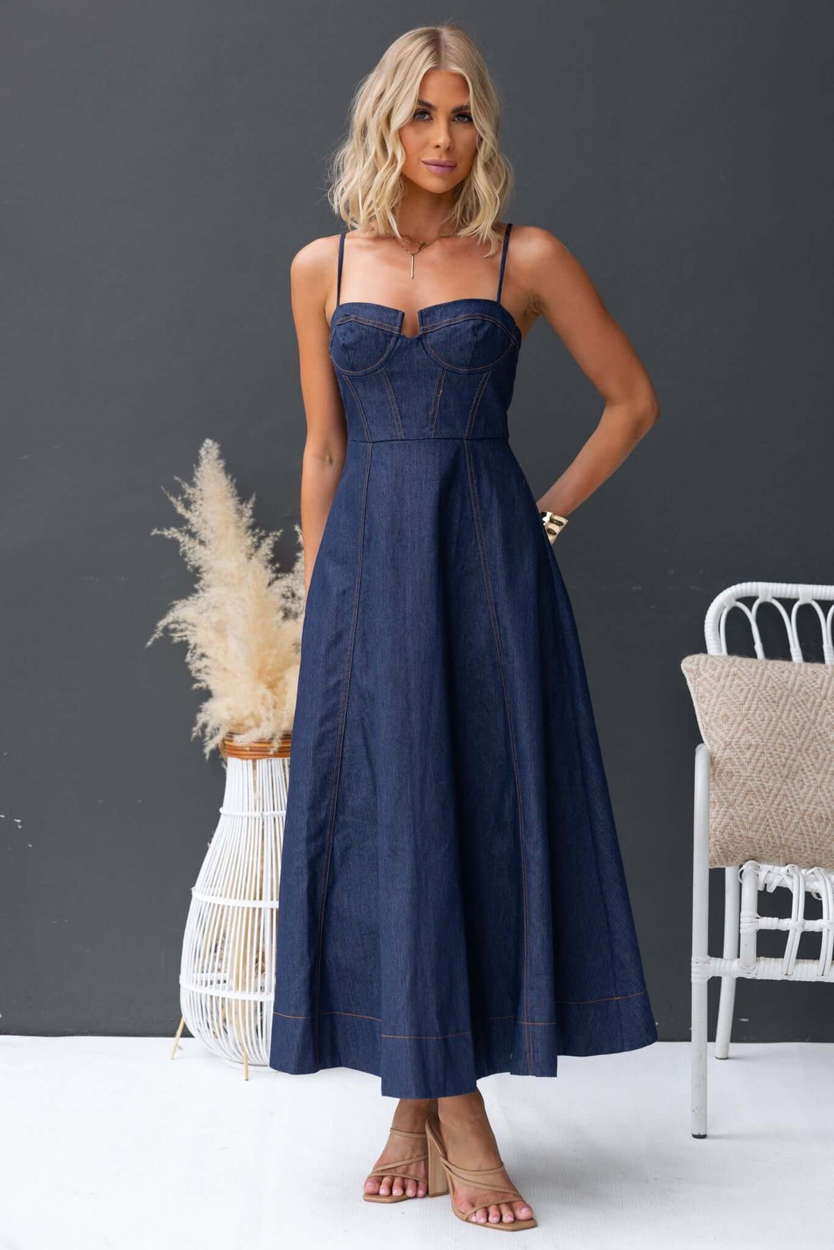 Sylvi Denim Midi Dress featuring adjustable straps and boning at bust, styled on model with neutral background.