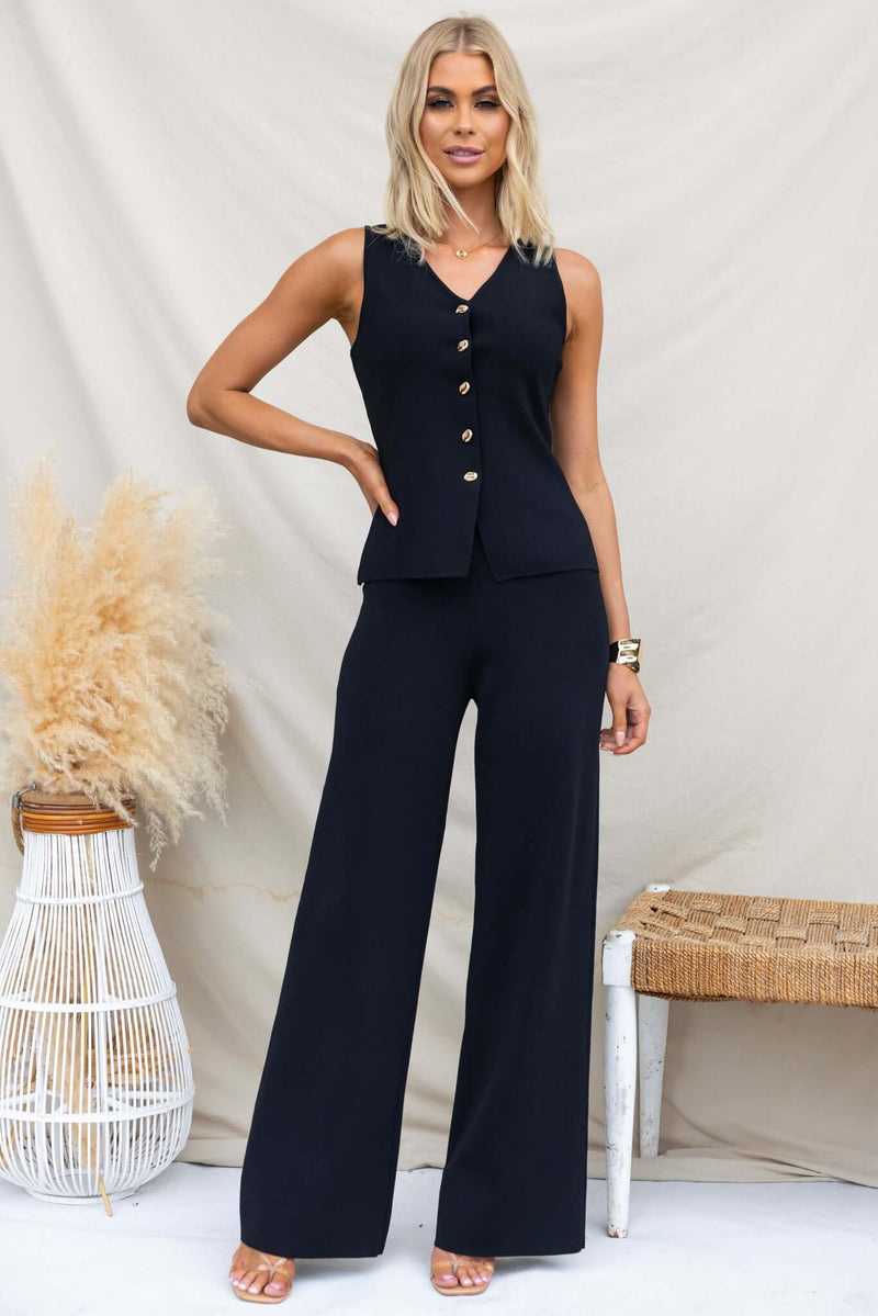 Tammie Pants in mid-high waist fit with elastic waistband, worn by a model in a stylish black outfit.