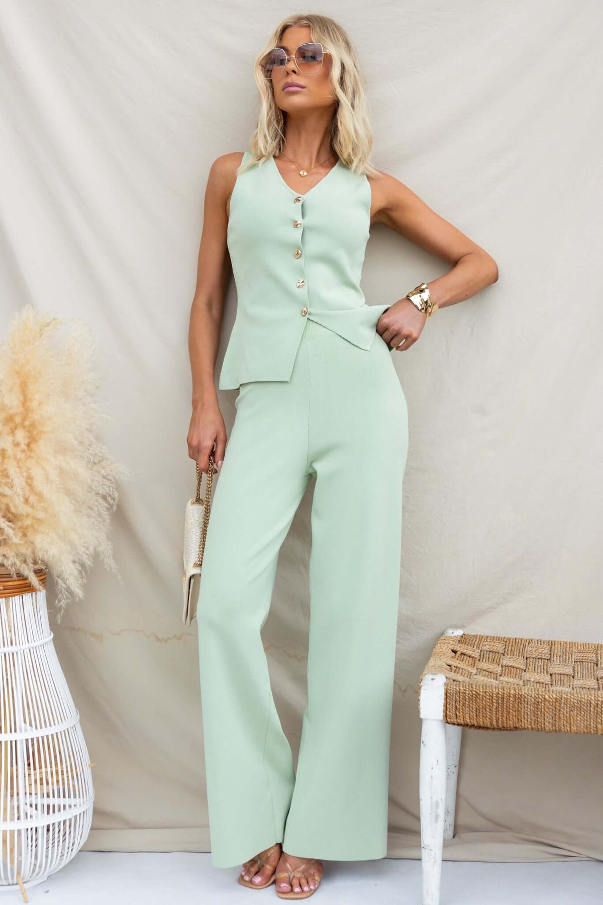 Model wearing Tammie Top in mint green, featuring a button-up front and stylish flared pants.