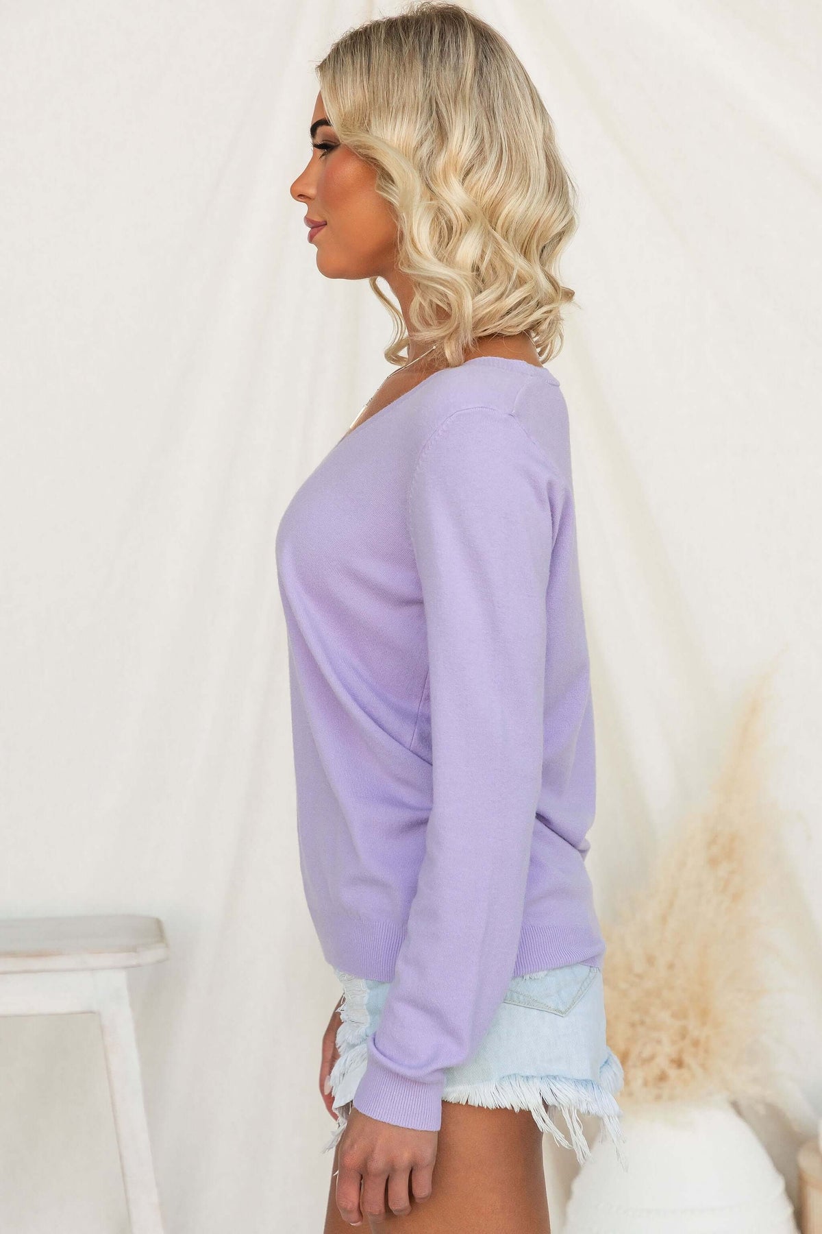 Model wearing Tayla Top in light purple, showing a side view of the V-neckline and lightweight knit material.