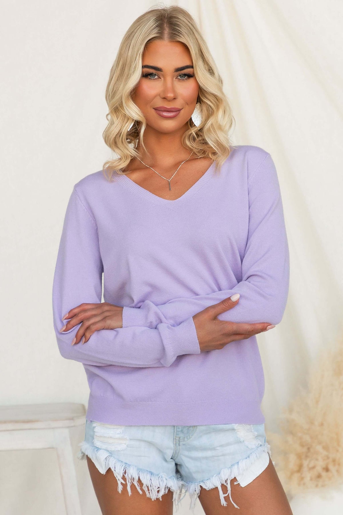 Tayla Top in lavender, featuring a V-neckline and lightweight knit material, styled with denim shorts.