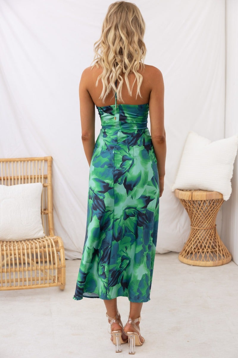 Model wearing the Meghan Midi Dress in green floral print from the back with adjustable straps.