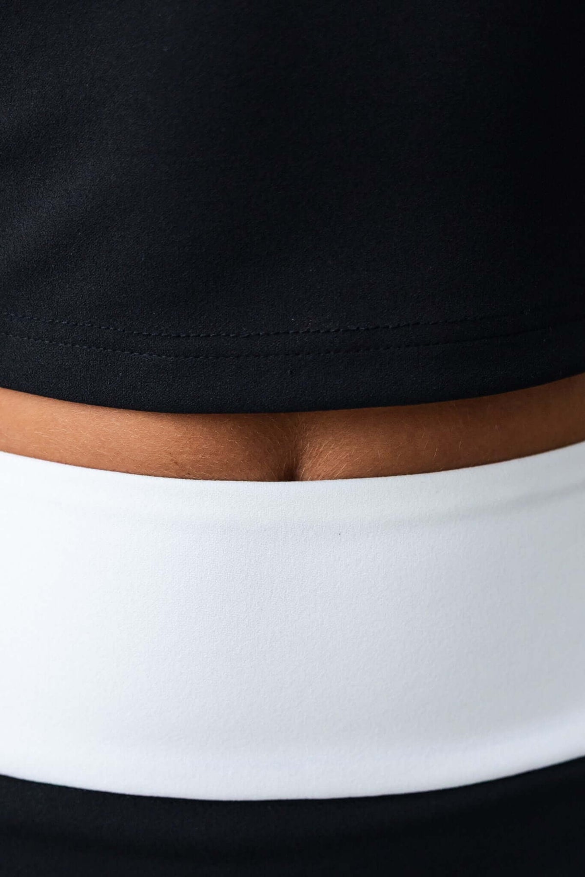 Close-up of the mid-high waist of the Thoren Maxi Skirt, showcasing the contrasting black and white band for a stylish look.