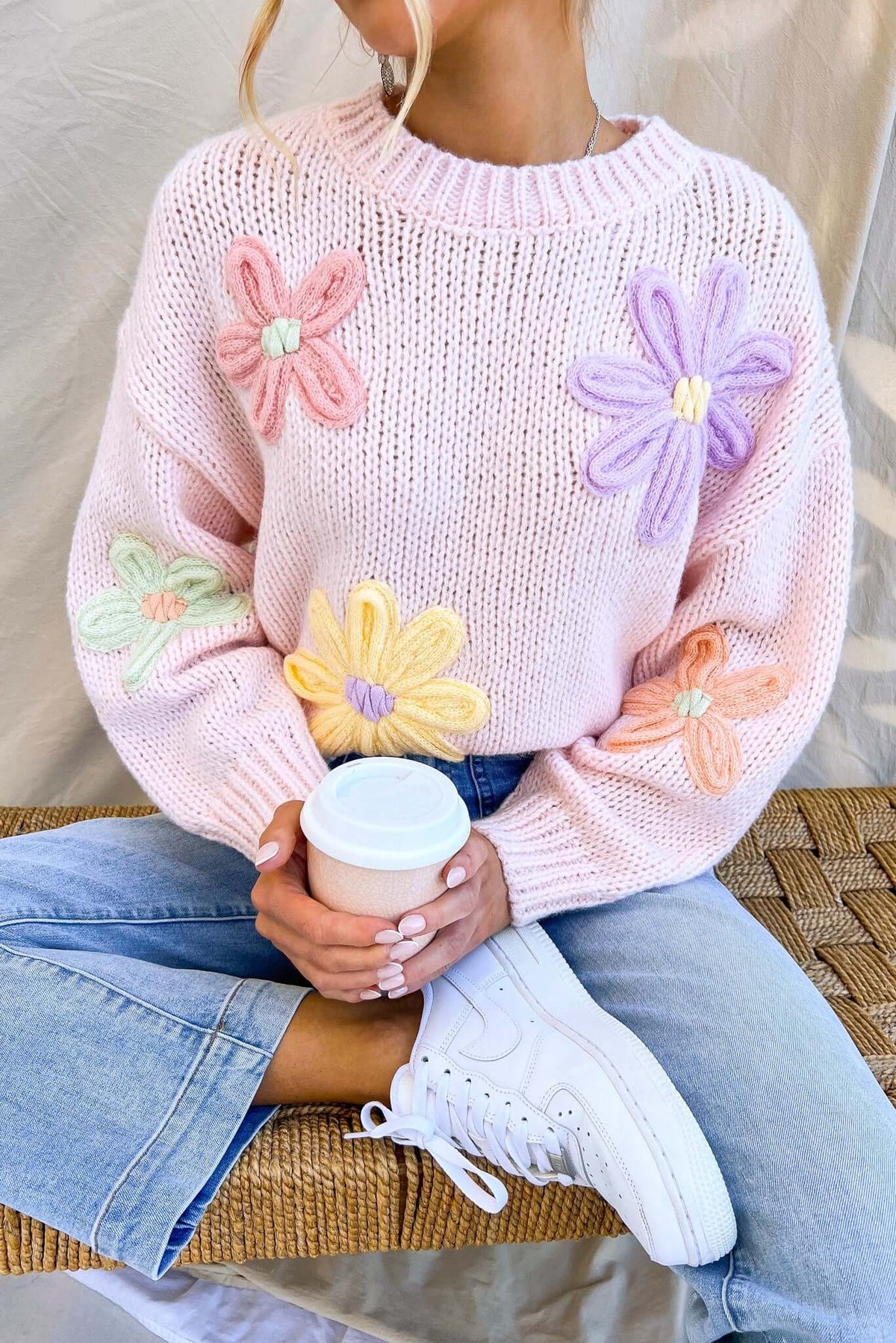 Thought Of You Jumper in pink with embroidered flowers, round neckline, relaxed fit, styled with denim and a coffee cup.