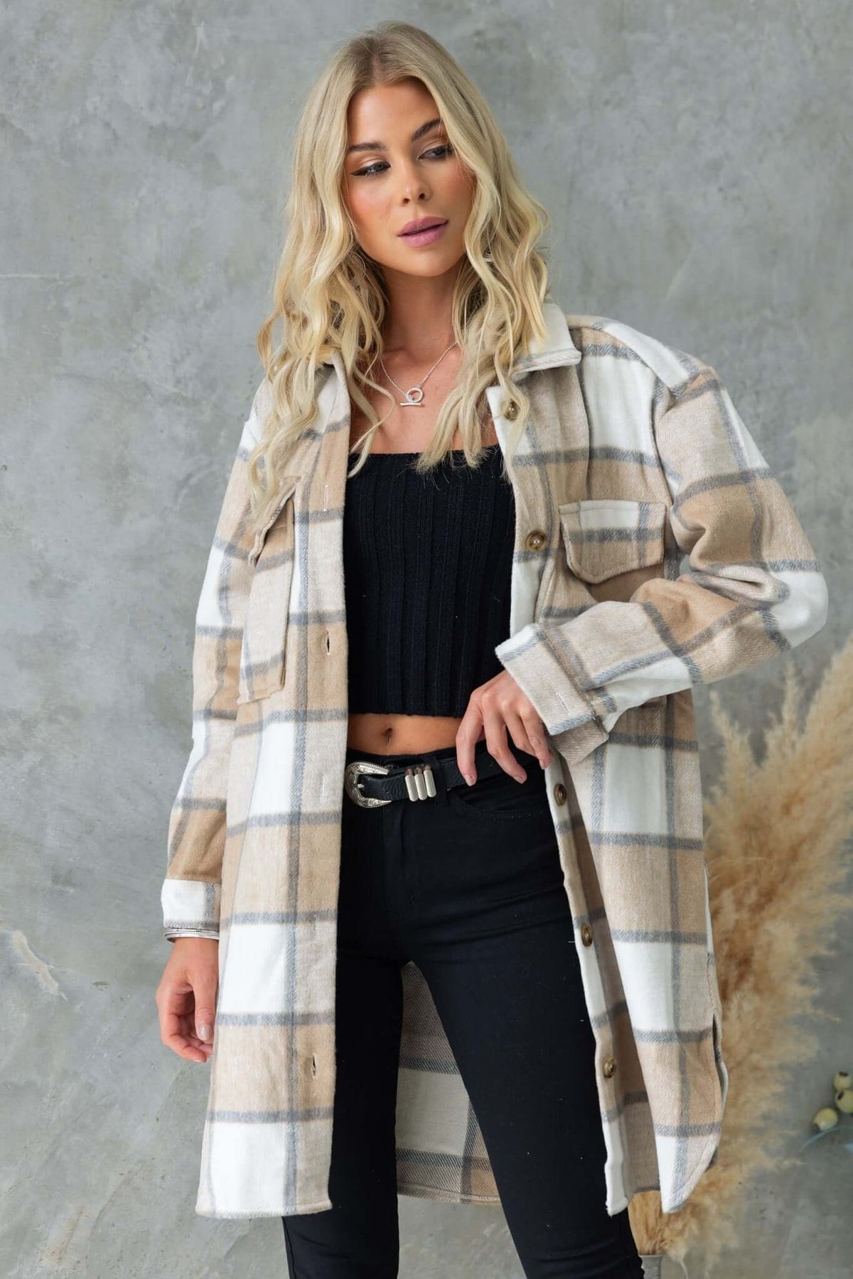 Model wearing a stylish Torres shacket with a button-up front, collar, and pockets, paired with black pants.