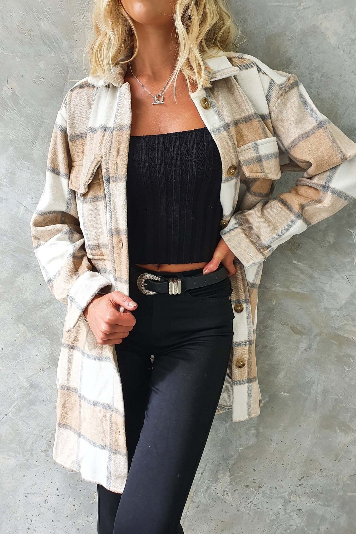 Model wearing a plaid Torres shacket with a button-up front and bust pockets, styled over a black top.