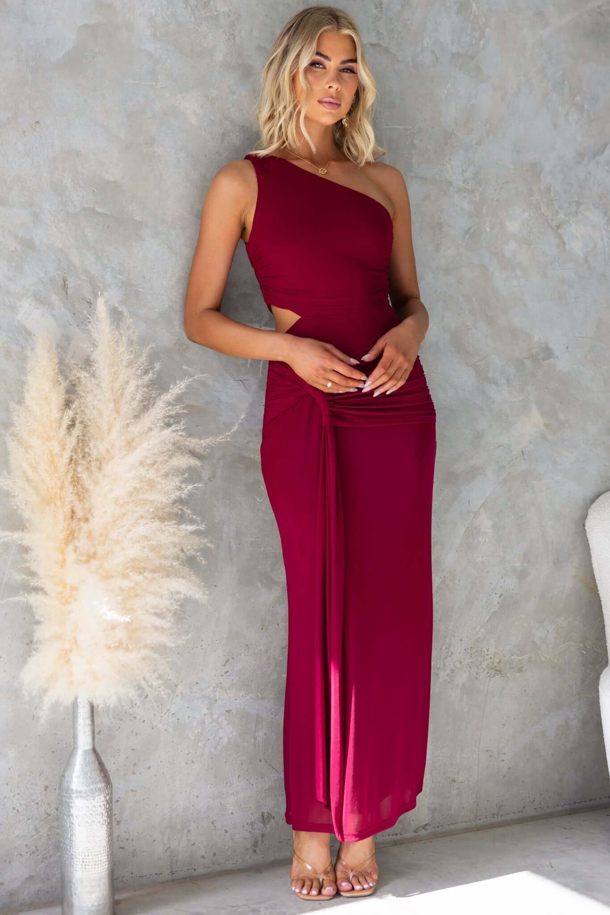 Ultra Maxi Dress in burgundy with one-shoulder neckline and cut-out waist, showcasing a stylish mesh design.