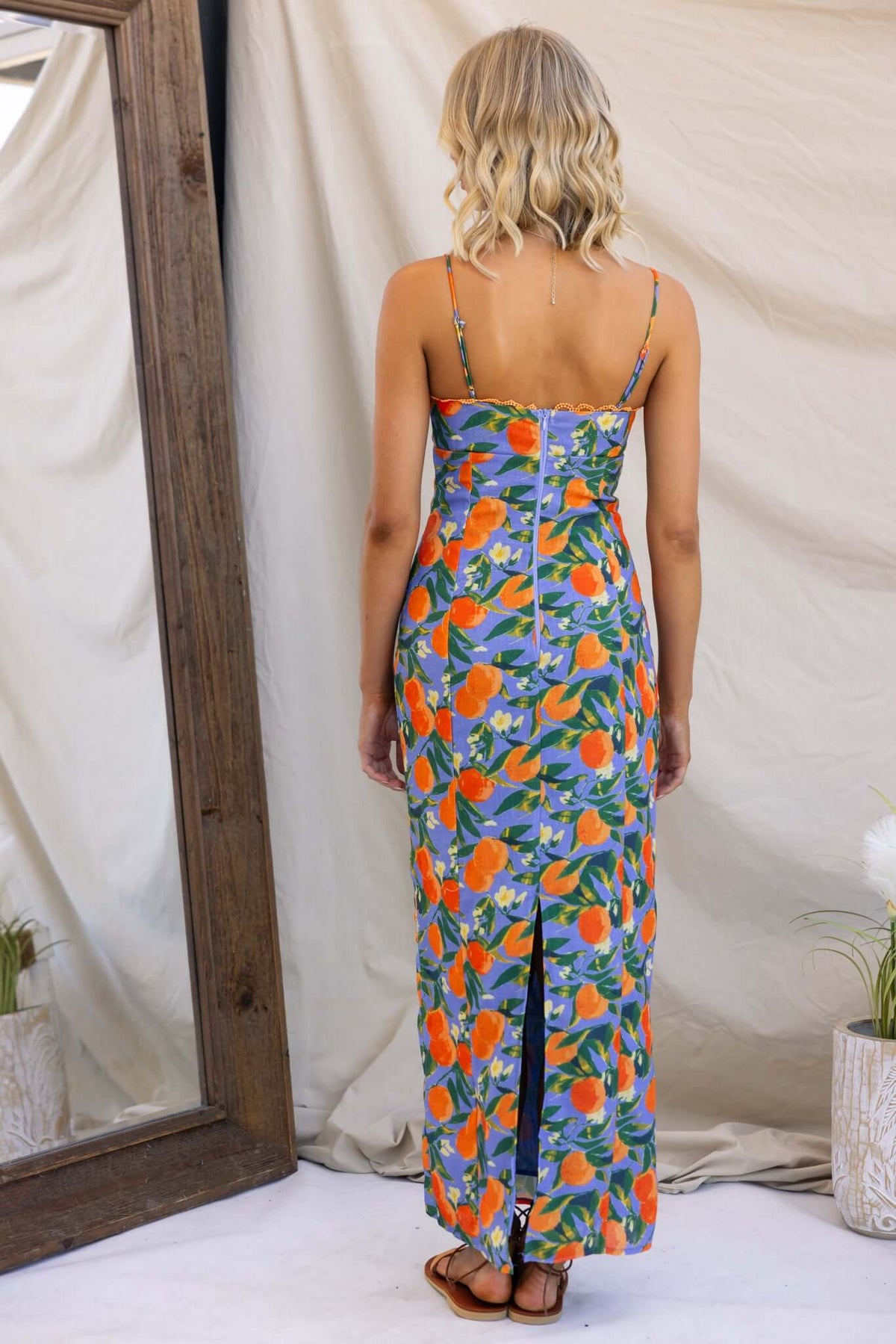 Model in Umeeka Maxi Dress with floral print, showcasing adjustable straps and back slit.