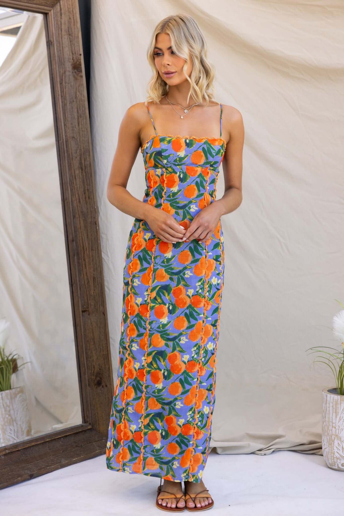 Umeeka Maxi Dress on model with floral pattern, adjustable straps, split back, showcasing summer style in vibrant colors.