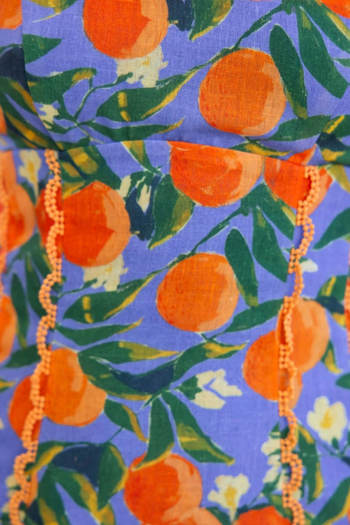 Close-up of Umeeka Maxi Dress with vibrant orange and green floral pattern on blue background.