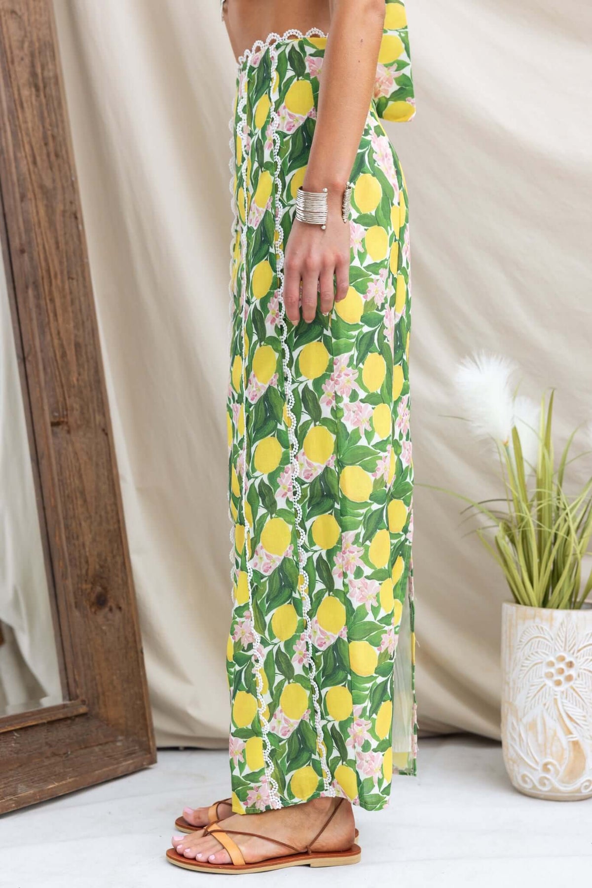 Side view of Umeeka Maxi Skirt featuring a floral and lemon print, mid-high waist, and back split.