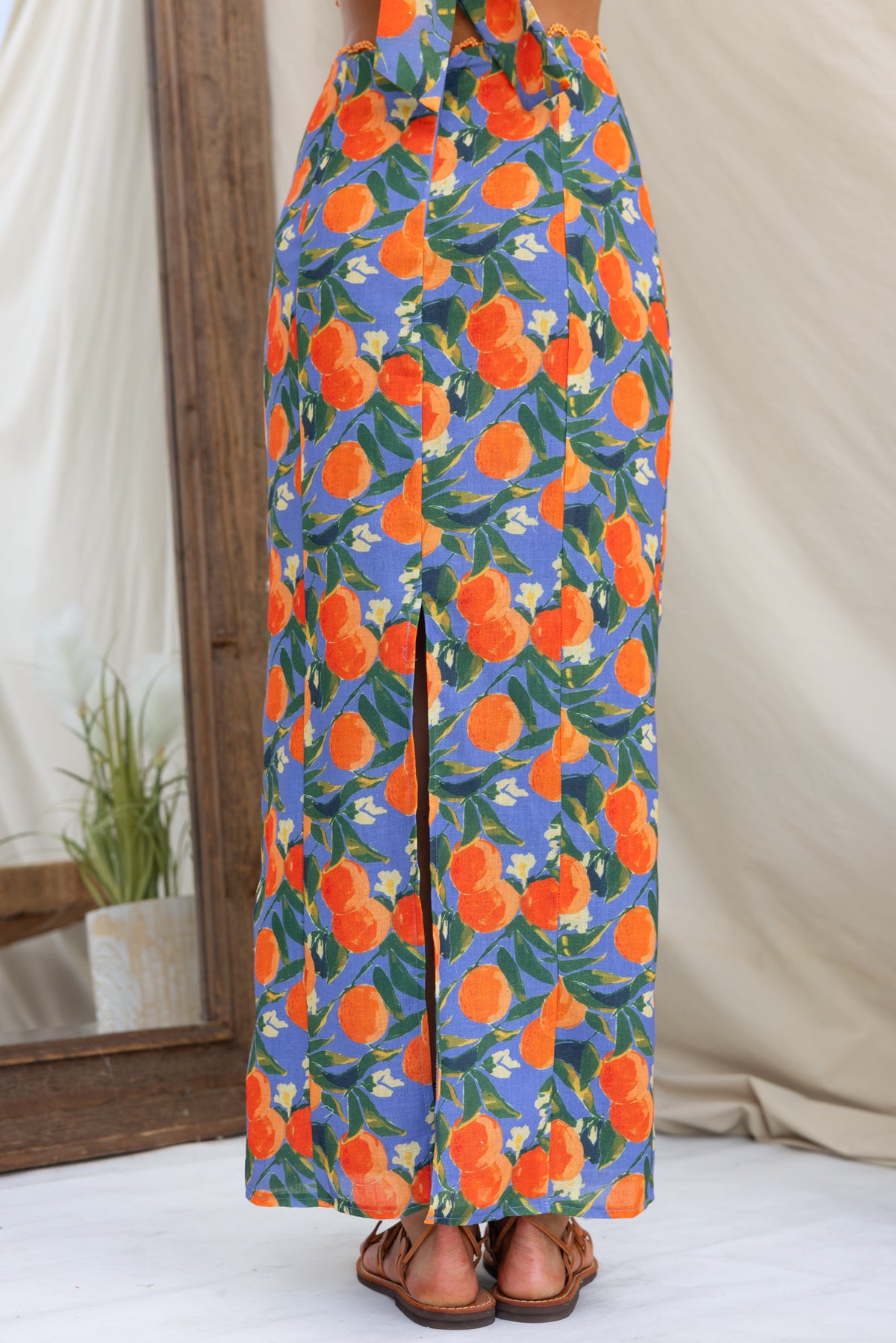 Umeeka Maxi Skirt with floral orange print, mid-high waist fit, back split and lined design, perfect for summer styling.
