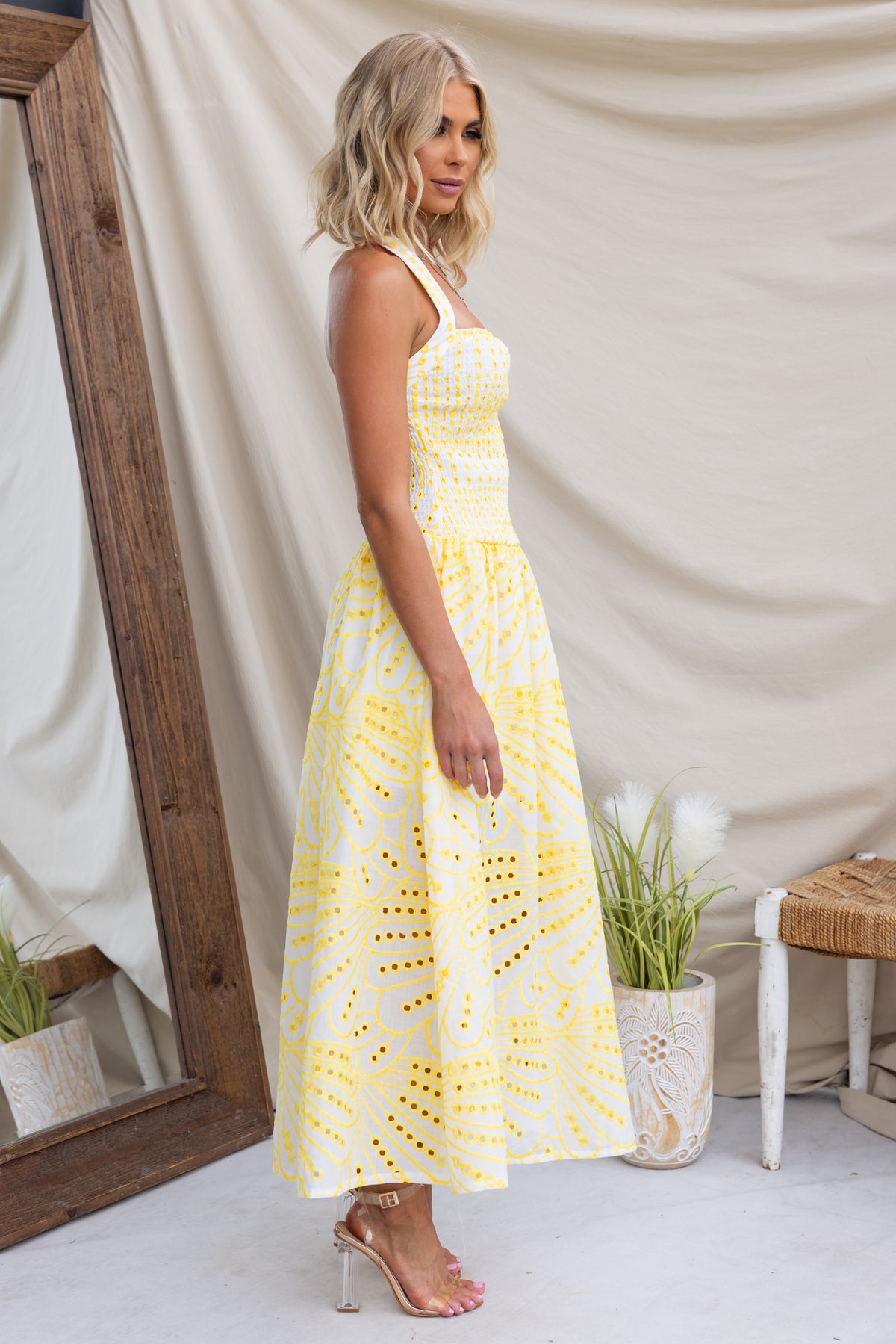 Urena Midi Dress with halter neckline, elastic bodice, and yellow anglaise fabric, displayed by model.