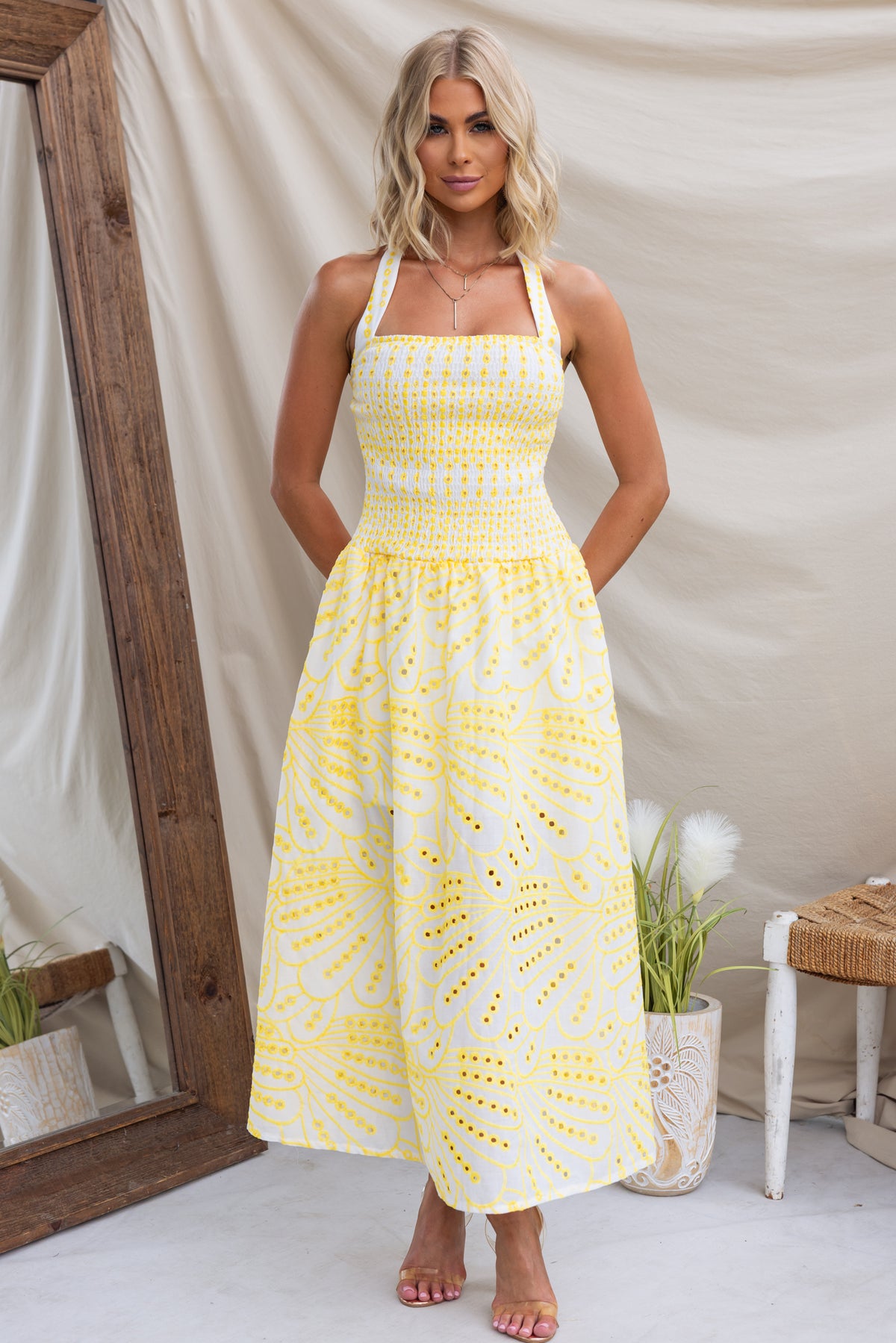 Urena Midi Dress in yellow with halter neckline and elastic bodice, featuring Anglaise material and a mid-thigh lining.
