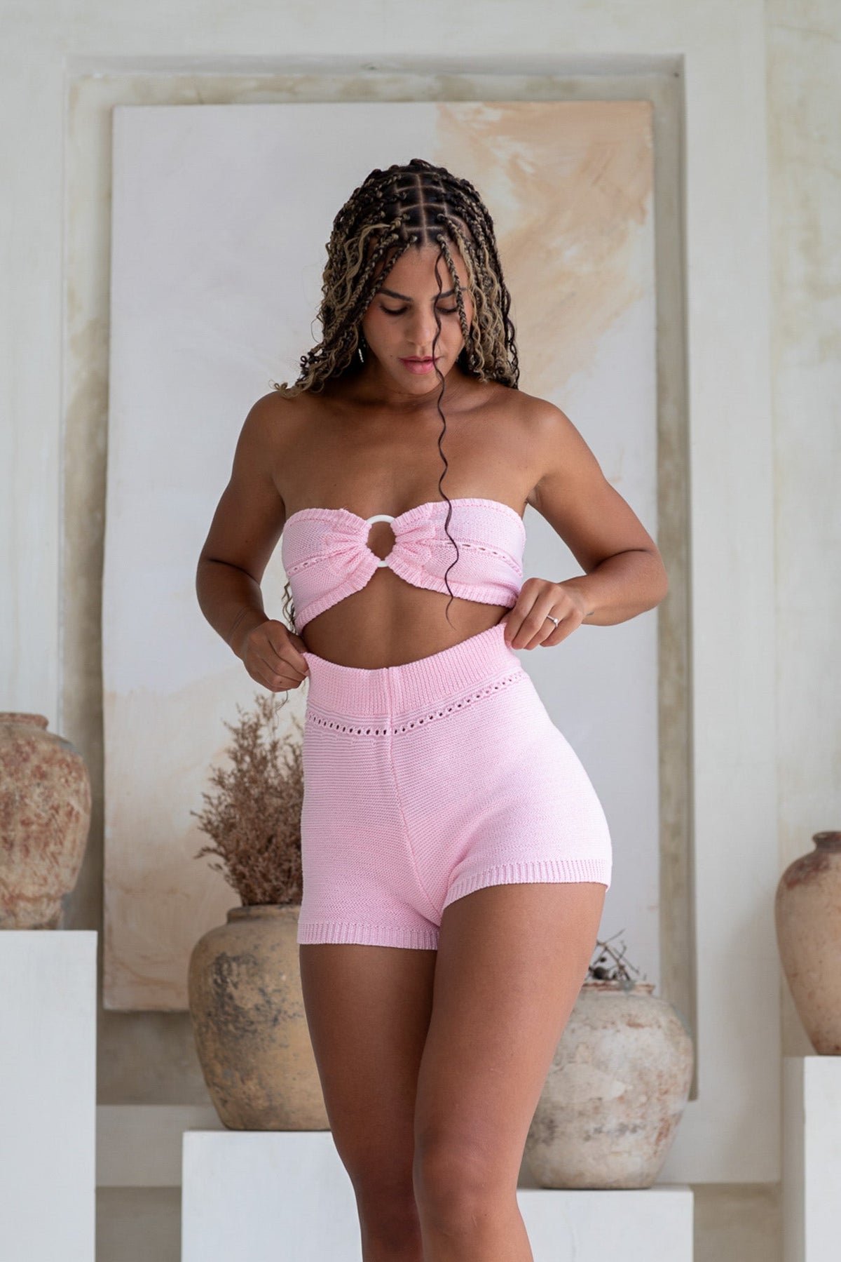 Model wearing Pearla Shorts in pink with a mid-high waist, showcasing a stylish knit design and elastic waistband.
