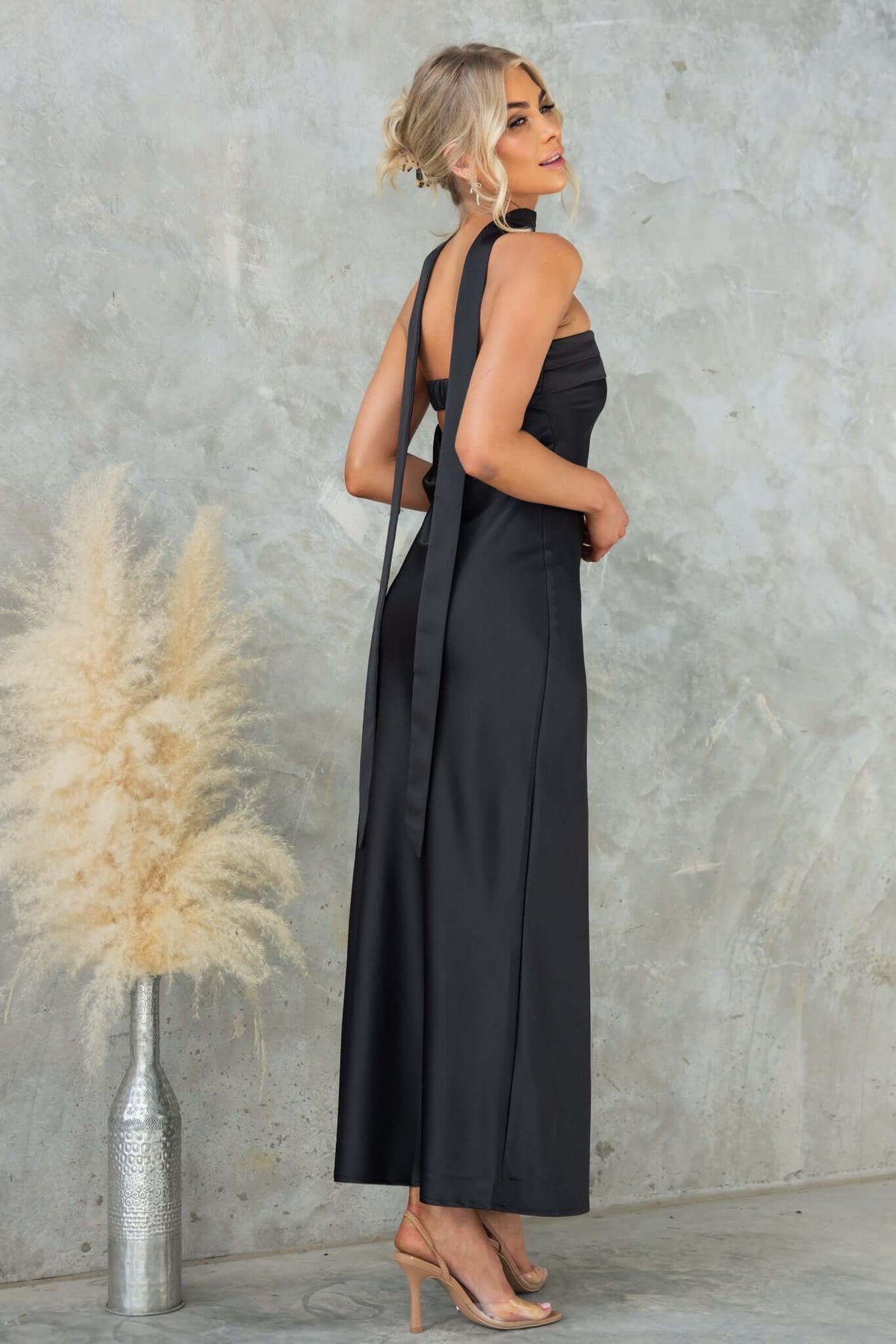 Model wearing the Verda Maxi Dress by Amaroso Bridal, showcasing its strapless design and elegant silhouette.