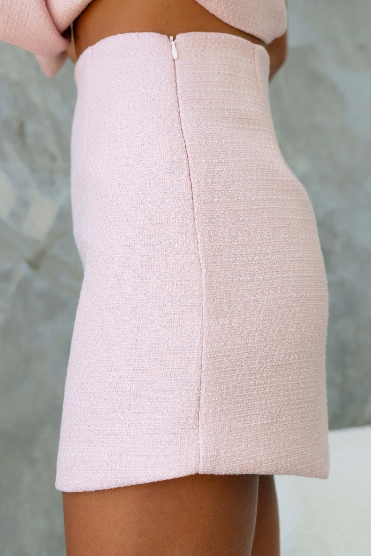 Side view of the Tiffany Skirt showcasing textured pink chenille fabric and an invisible zip closure.