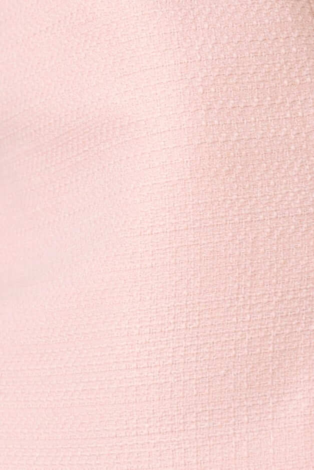 Close-up of textured chenille fabric in soft pink, showcasing a subtle woven pattern.