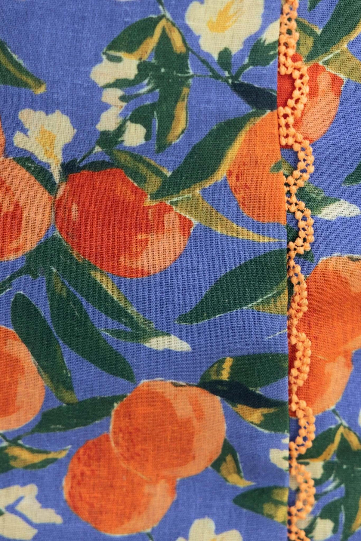 Close-up of Umeeka Top fabric featuring orange and white floral patterns on a blue background.