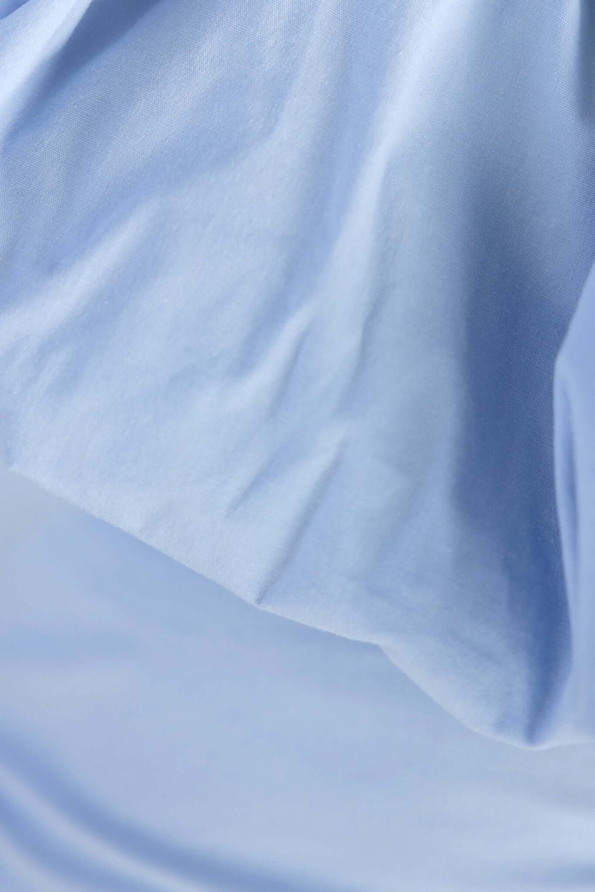 Close-up of soft, stretchy cotton fabric in light blue, ideal for a Vitoria Maxi Dress.