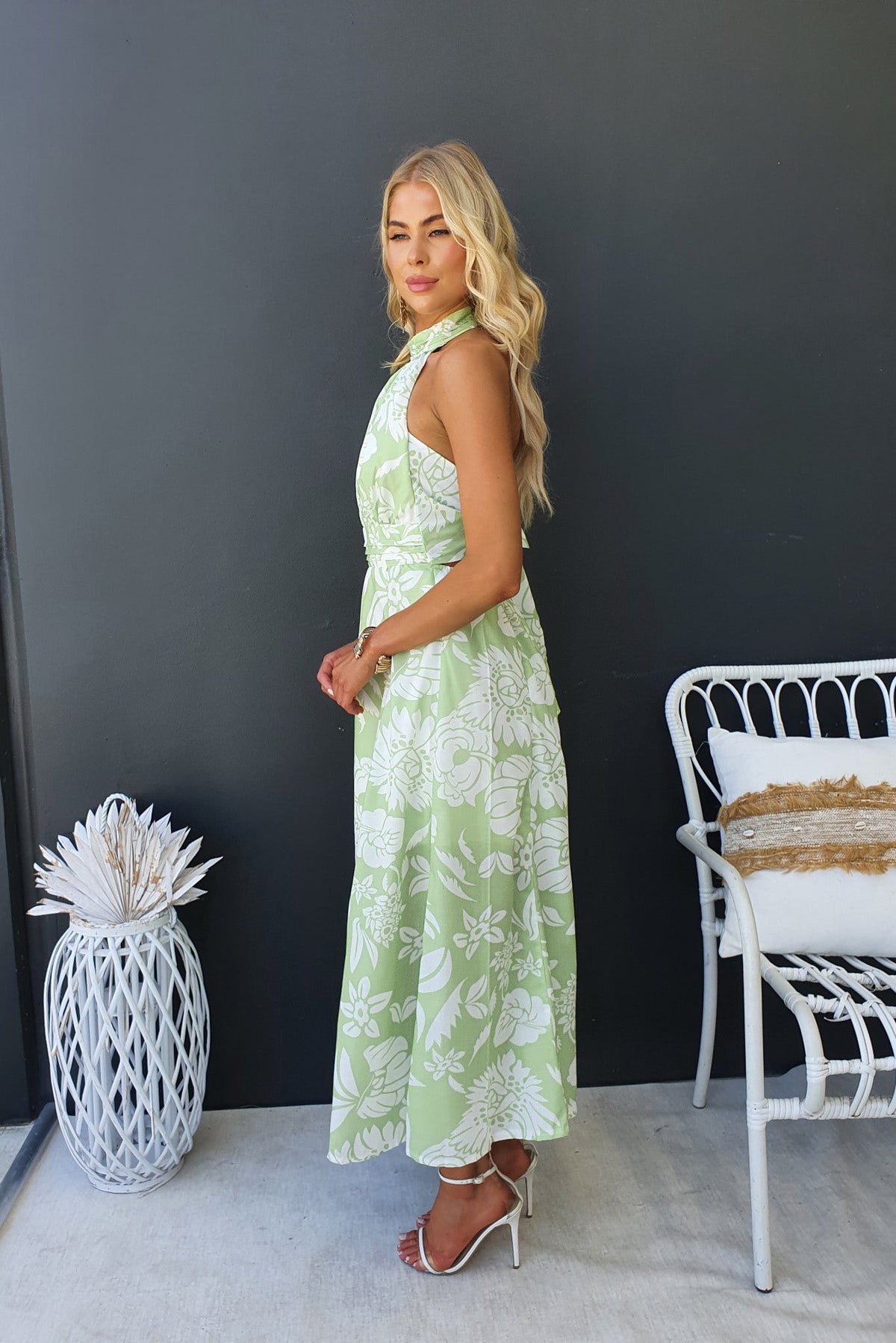 Corio Midi Dress in green floral print, featuring adjustable tie halter neckline and elastic back, styled casually.