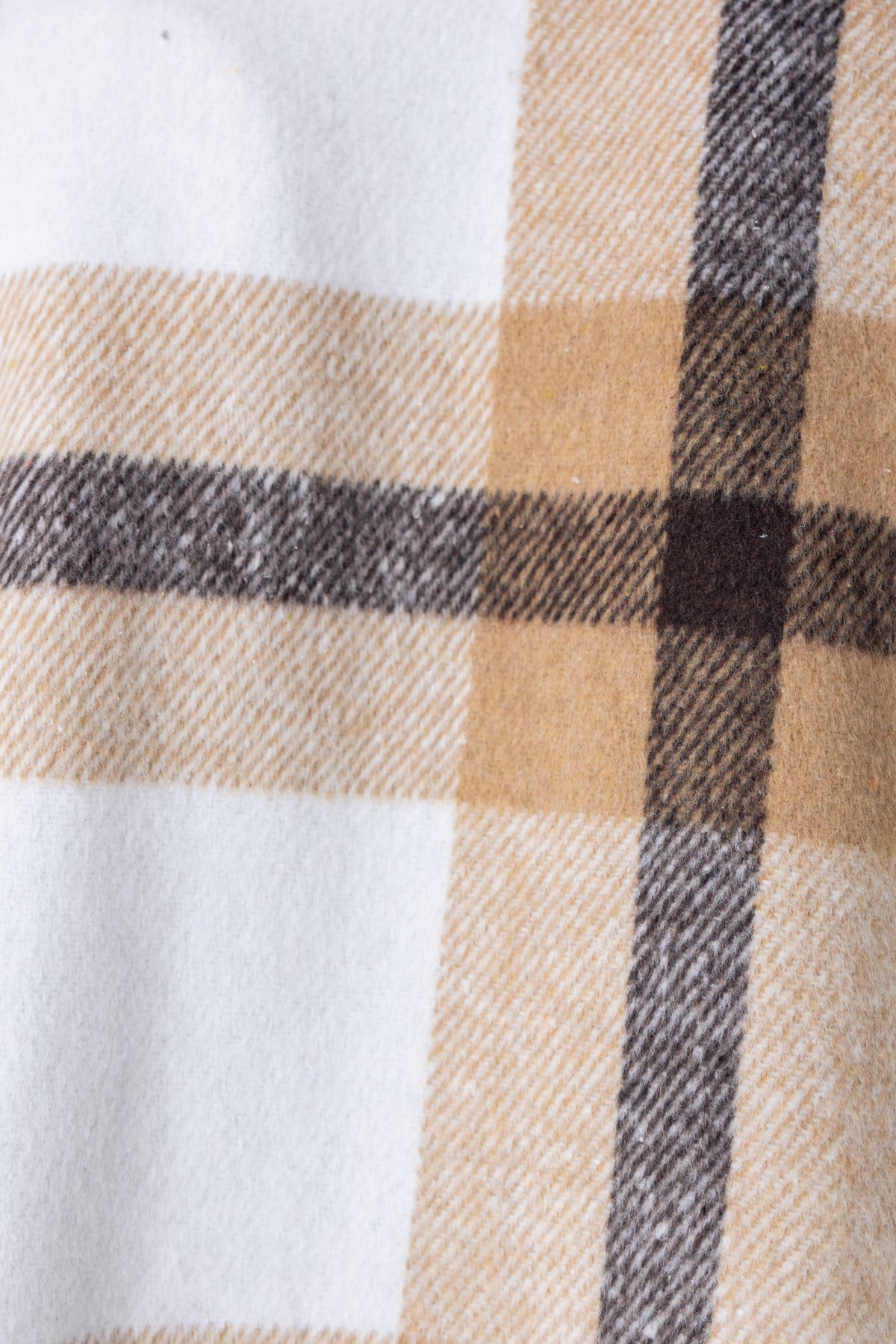 Close-up of Whessler Shacket's textured plaid fabric in warm tones of beige, brown, and cream.