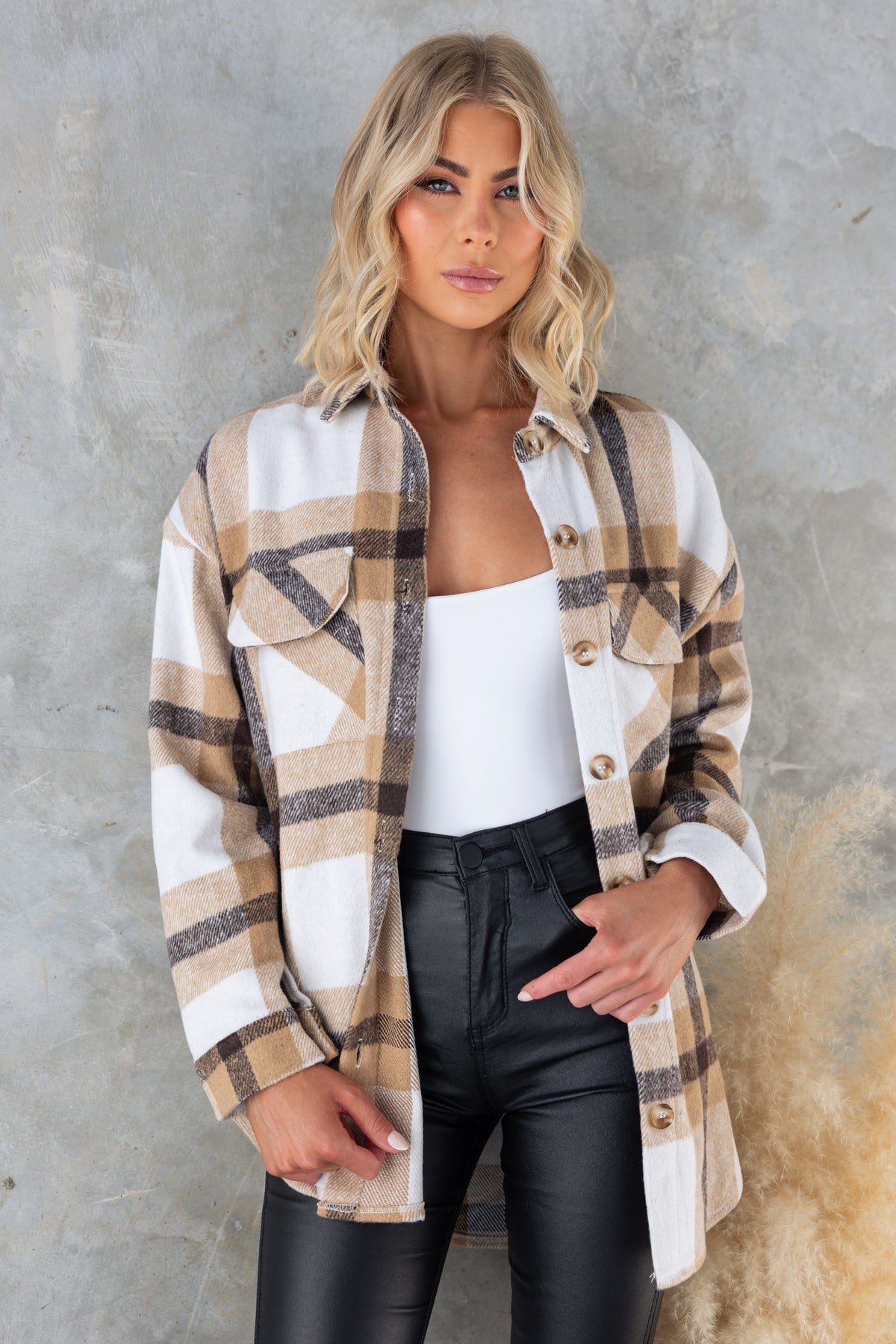 Woman wearing a Whessler shacket with a button-up front and plaid pattern, styled with black pants.