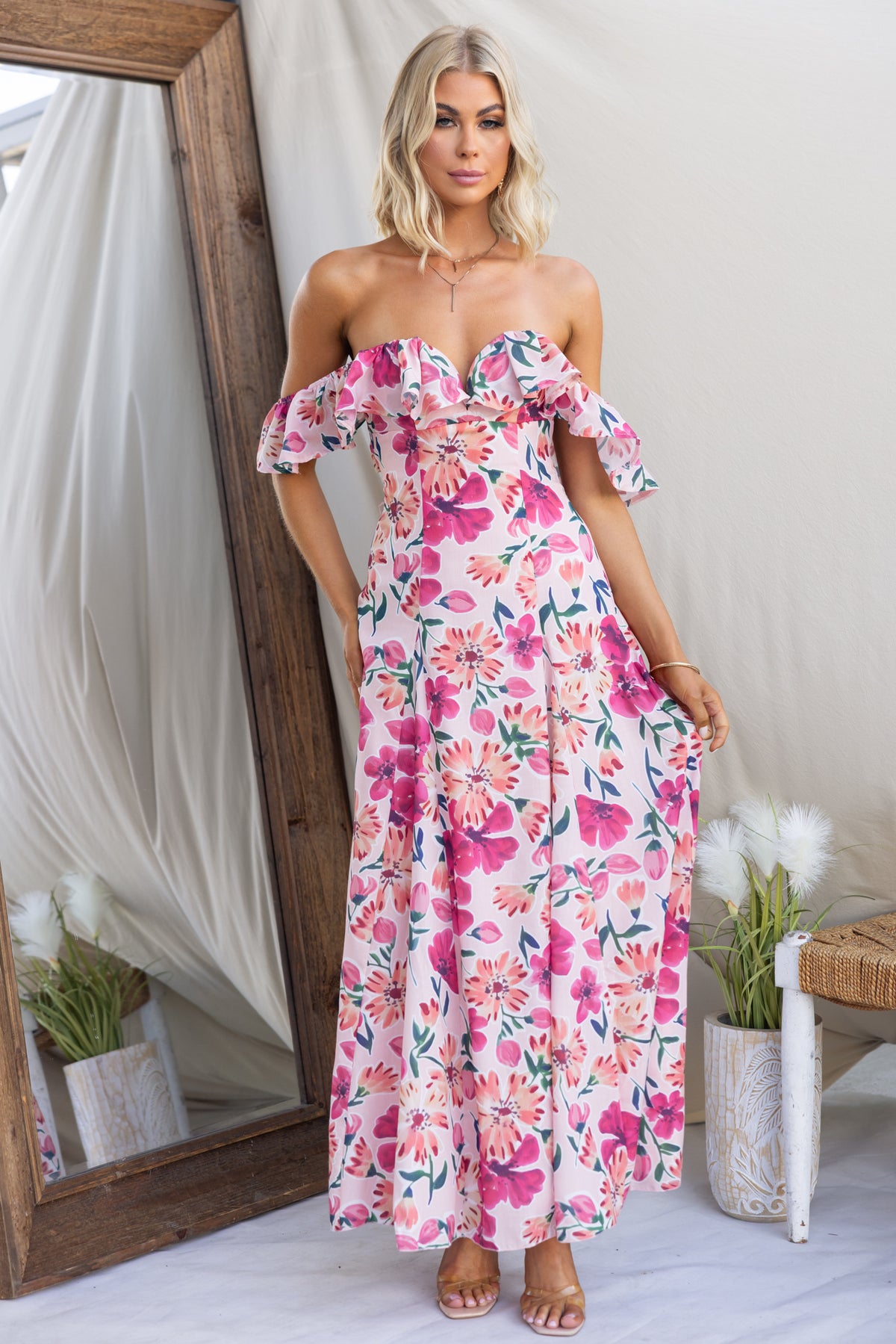 Wilma Maxi Dress with floral print, off-shoulder design, and ruffled sleeves displayed in a bright setting.