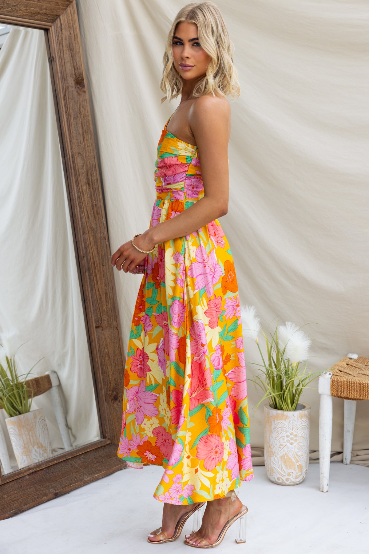 Woran Midi Dress featuring a vibrant floral print, one-shoulder design, and elegant flowy silhouette in a stylish setting.