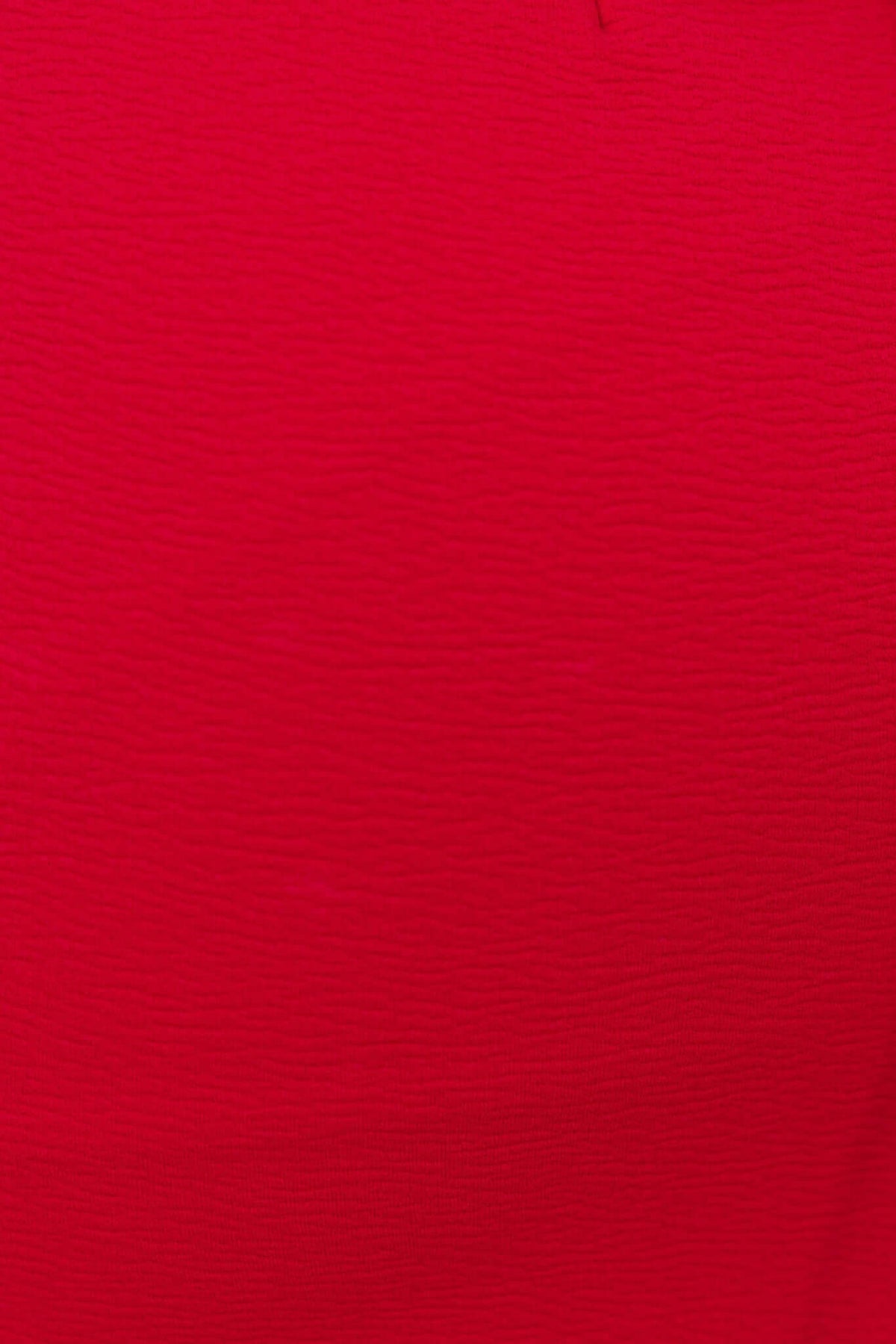 Close-up of textured red fabric, showcasing the vibrant color and soft stretch material used in the Wyetta Maxi Dress.